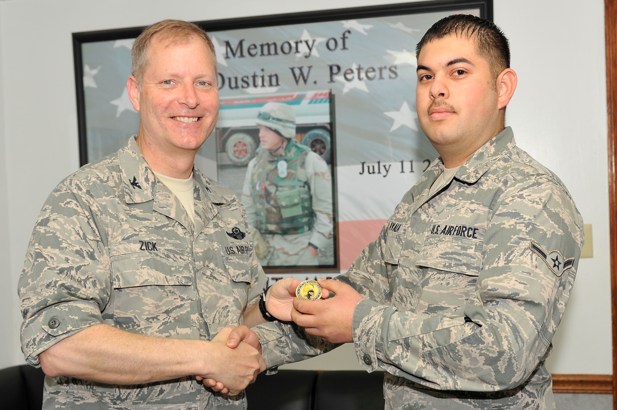 Col. Michael Zick, 19th Airlift Wing vice commander, presents a coin to Airman Fernando Ayala, 19th Logistics Readiness Squadron vehicle operator and dispatcher, April 6 at Bldg. 551 for his selection as the Combat Airlifter of the Week. Airman Ayala was hand selected by base leaders to transport the Air Education and Training Command commander during his base wide visit. (U.S. Air Force photo by Senior Airman Christine Clark)