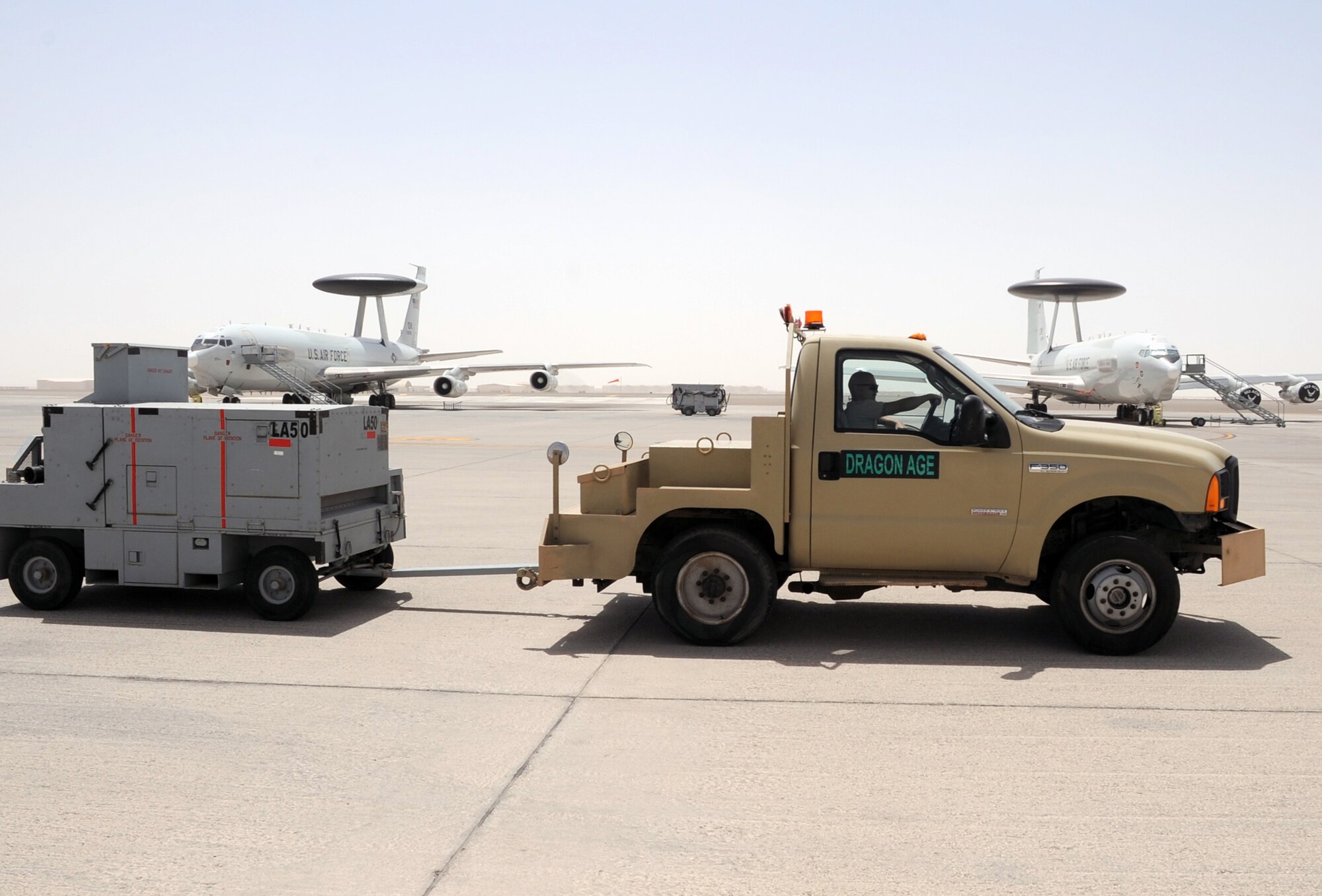 A maintenance Airman with the 380th Expeditionary Maintenance Squadron drives a truck pulling a generator past two E-3 Sentry Airborne Warning and Control System aircraft during maintenance operations at a non-disclosed base in Southwest Asia on April 2, 2010. The E-3 Sentry is assigned to the 965th Expeditionary Airborne Air Control Squadron of the 380th Air Expeditionary Wing. The 380th EMXS and the 965th EAACS, as part of the 380th AEW, support operations Iraqi Freedom and Enduring Freedom and the Combined Joint Task Force-Horn of Africa. (U.S. Air Force Photo/Master Sgt. Scott T. Sturkol/Released)