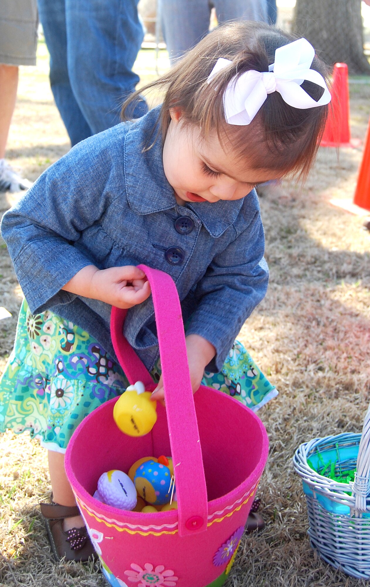 Maycee McCann, daughter of Capt. Greg and Monica McCann, puts a prize in her Easter egg basket during the annual base wide Easter Egg Hunt held April 3 at the Youth Center gym and the ground around the center. The egg hunt included a visit by the Easter Bunny. (U.S. Air Force photo/ Ashley Murphy)
