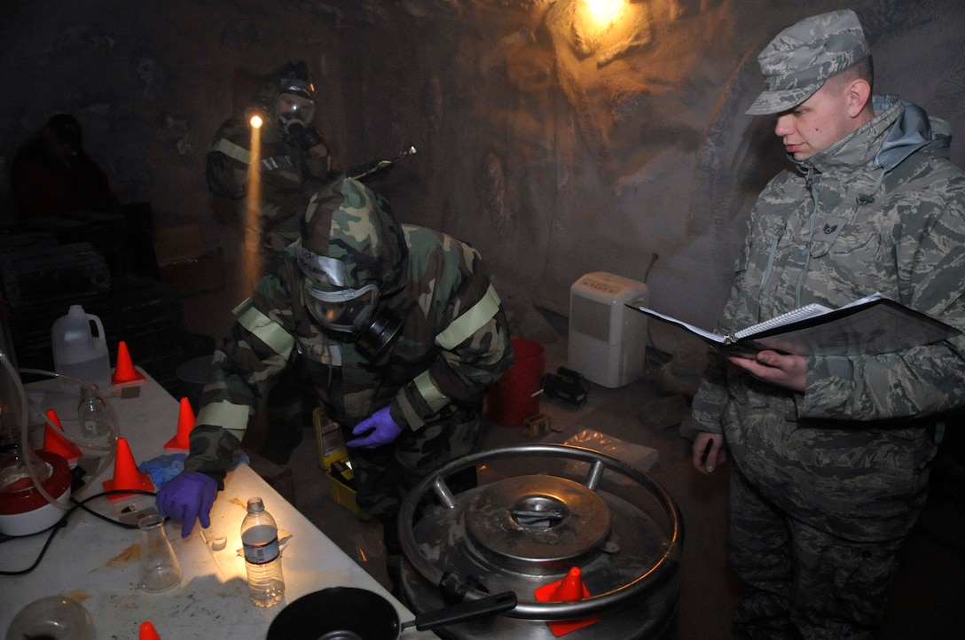 Airman 1st Class Eric Reist assists Staff Sgt. Charlotte Robinson in sampling an unknown liquid from a bottle at a simulated deployment location while being observed by Staff Sgt. Parker Stade, as part of the Air Force District of Washington chemical, biological, radiological, nuclear, and high yield explosives response force while training at the Center for National Response in Gallagher, W.Va., March 25, 2010. The response force is made up of personnel from the 316th Wing, the 79th Medical Wing and the 11th Wing and is a force that combines the bioenvironmental engineers, civil engineering readiness, emergency management and fire emergency services to respond to emergency situations in the National Capital Region. (U.S. Air Force photo by Staff Sgt. Renae L. Saylock)