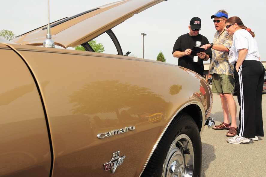 SHAW AIR FORCE BASE, S.C. -- Mike Madsen (middle) and Master Sgt. Marsha Madsen, 20th Force Support Squadron Airman and Family Readiness Center readiness NCO-in-charge, show off their 1967 Chevy Camaro SS to Major Terry Wanner, 20th Component Maintenance Squadron operations officer, during a car show here April 3. The 2010 Shaw Car Show was sponsored by the Army and Air Force Exchange Service. (U.S Air Force photo/Senior Airman David Minor)