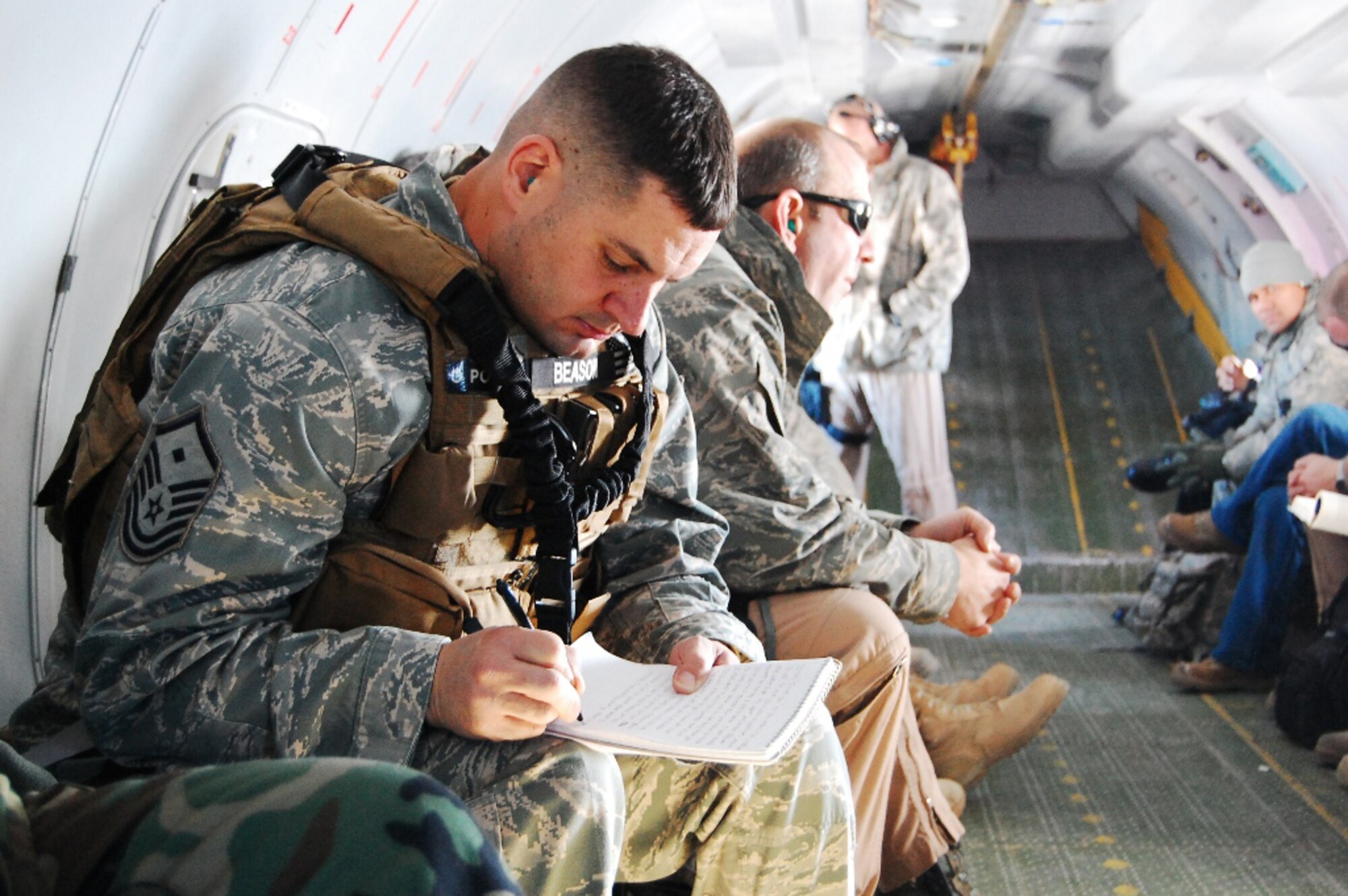 Air Force First Sergeant Bubba Beason of the 438th Air Expeditionary Wing pens his thoughts while flying on an An-32 to Herat, Afghanistan, Feb. 9, 2010. (U.S. Air Force photo by Master Sergeant Joseph Grunditz/released)