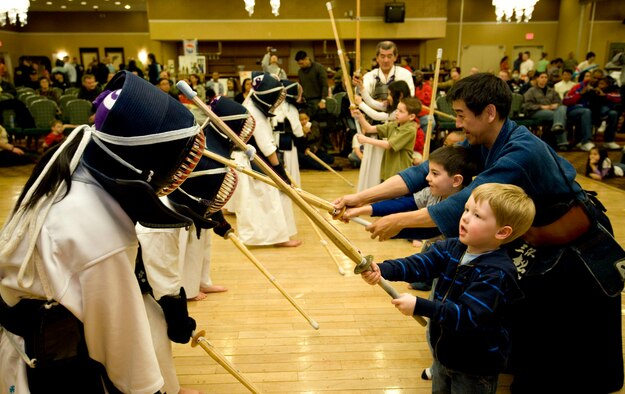 MISAWA AIR BASE, Japan -- Members and instructors from the Misawa Youth Kendo Team teach American children how to perform a head strike during Japan Day April 3 at the Collocated Club. The kendo team was one of three martial arts organizations who demonstrated their disciplines and offered Americans a chance to try them. (U.S. Air Force photo/Staff Sgt. Samuel Morse)