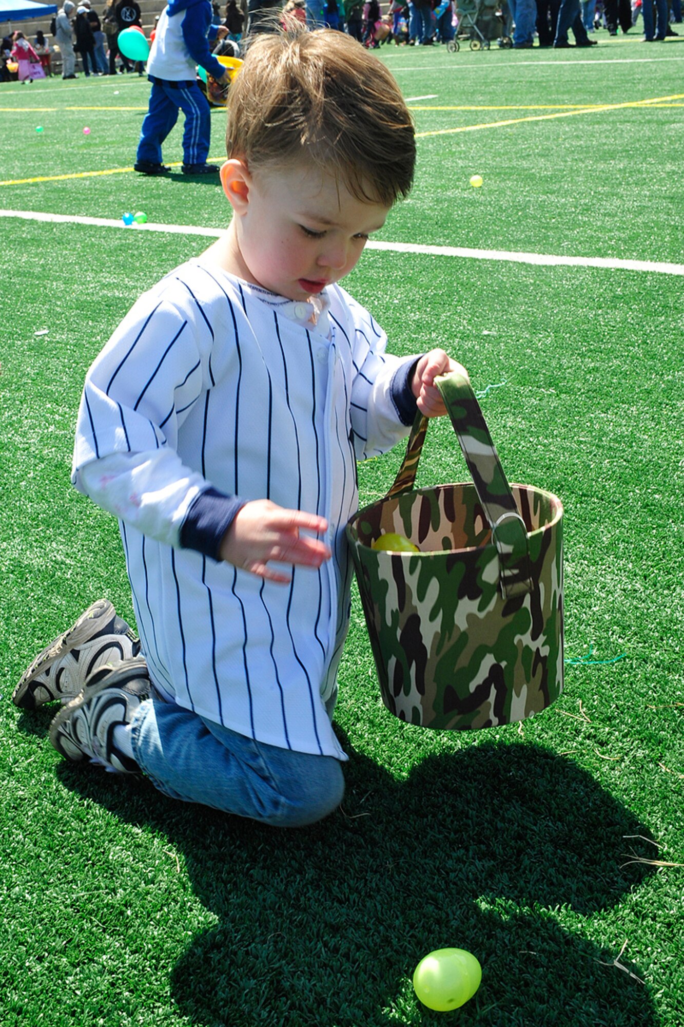 Three-year-old Wyatt Jones collects eggs during the annual Easter celebration at Osan Air Base, Republic of Korea, April 3. The day's festivities also included a "Child Abuse Prevention" parade, a live band performance and an appearance by the Easter bunny. (U.S. Air Force photo/Staff Sgt. Eunique Stevens)