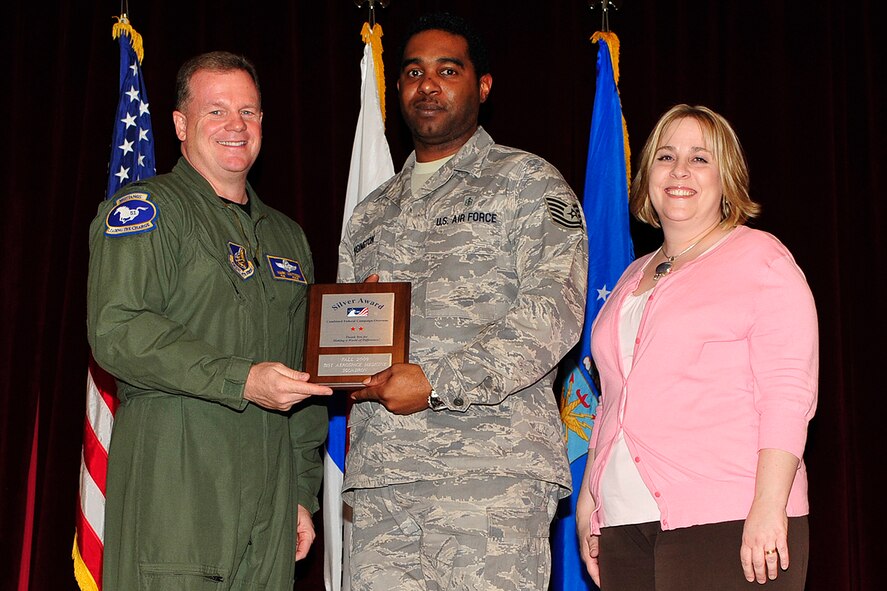 Tech. Sgt. Thomas Wigington, 51st Aerospace Medicine Squadron, accepts a "silver" award from Col. Mark Mattison, 51st Fighter Wing vice commander, and Mrs. Constance Baker, Osan Combined Federal Campaign director, at an awards ceremony held at Osan Air Base, Republic of Korea, April 2. Bronze, silver, gold, and platinum awards were presented to the units who collectively donated the most during the campaign this past year. (U.S. Air Force photo/Staff Sgt. Eunique Stevens)