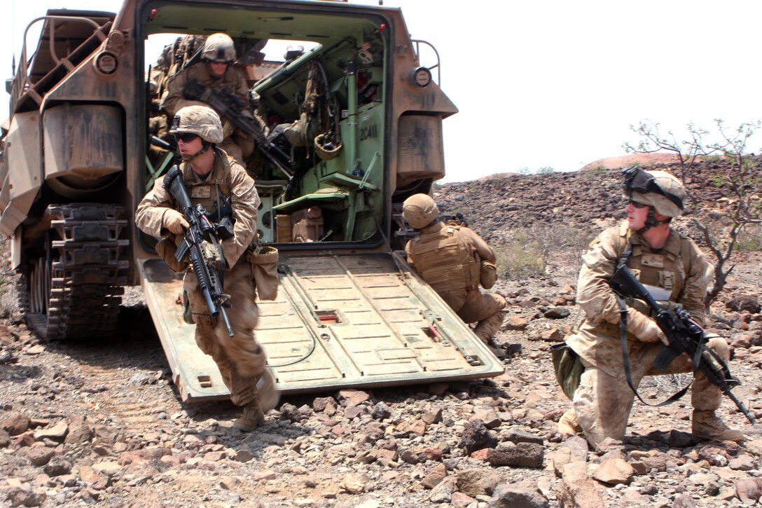 U.S. Marine Corps Cpl. Daniel Mallory secures the rear of an amphibious assault vehicle as Lance Cpl. Daniel Pursley leads his team towards their objective point during a mechanized assault as part of a live fire range in Djibouti, March 29, 2010. Mallory and Pursley are assigned to 1st platoon, Alpha Company, Battalion Landing Team 1st Battalion, 9th Marine Regiment, 24th Marine Expeditionary Unit. Amphibious Assault Vehicle platoon transported and supported infantry Marines throughout mountainous environment. The 24th MEU Marines performed a series of sustainment and joint exercises alongside the French military servicemembers while in Djibouti. The 24th MEU is currently serves as the theatre reserve force for Central Command during its seven month deployment aboard Nassau Amphibious Ready Group vessels.