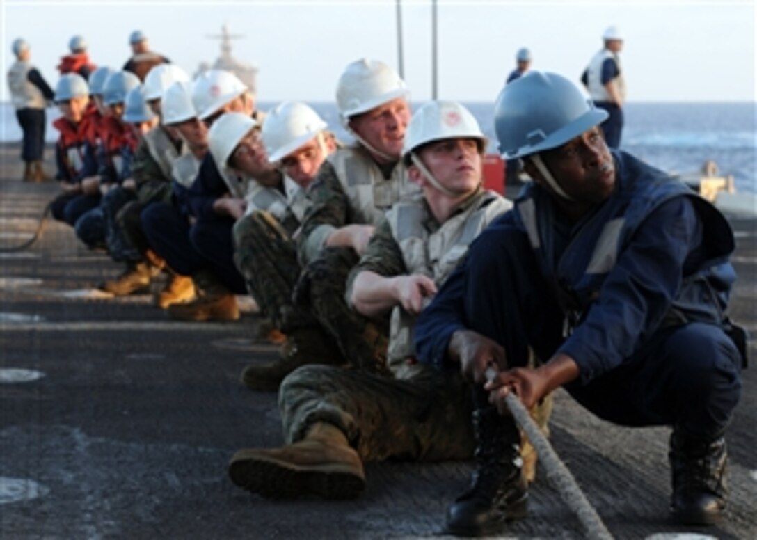 U.S. Navy sailors and Marines assigned to the amphibious transport dock USS Denver (LPD 9) hold a line in place while trying to secure a span wire during a connected replenishment with Military Sealift Command underway replenishment oiler USNS Tippecanoe (T-AO-199) in the Pacific Ocean on March 19, 2010.  The Denver is part of the Essex Amphibious Ready Group and is conducting spring patrol.  