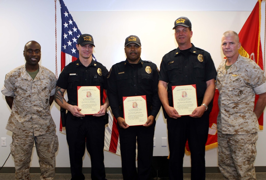 Lt. Col. Vernon Graham, the provost marshall, Cpl. James White, Cpl. Michael McLiechy, Cpl. Kevin Marnet and Col. Frank A. Richie, the commanding officer of MCAS Miramar, pose for a picture after the Marine Corps Civilian Police officers were promoted here April 6.