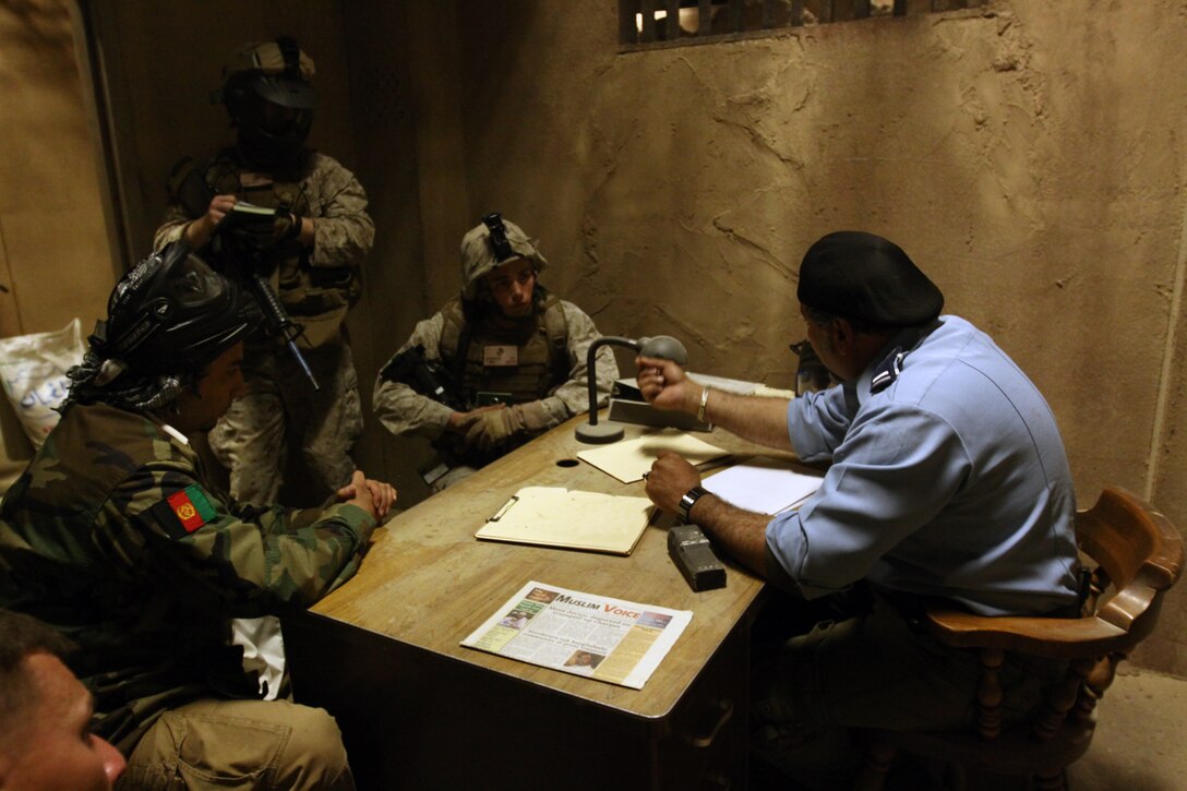 Marines with Weapons Company, 1st Battalion, 1st Marine Regiment, 1st Marine Division, use their Afghan role-playing translator to speak with the local police chief actor inside Camp Pendleton’s Infantry Immersion Trainer, April 7. The 32,000-square-foot military urban training facility was recently changed from a simulated Iraqi village, to resemble the Afghan village of Now Zad, after the Headquarters Marine Corps officials made the decision March 15, to modify the training environment.