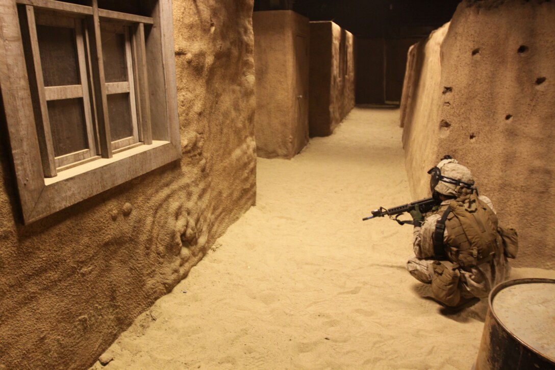 A Marine with Weapons Company, 1st Battalion, 1st Marine Regiment, 1st Marine Division, anticipates a simulated attack at Camp Pendleton’s Infantry Immersion Trainer, April 7. The 32,000-square-foot military urban training facility was recently changed from a simulated Iraqi village, to resemble the Afghan village of Now Zad, after the Headquarters Marine Corps officials made the decision March 15, to modify the training environment.