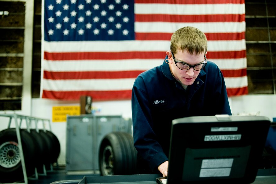 Senior Airman Scott Alberts, 62nd Maintenance Squadron, enters data into a laptop while servicing aircraft tires at McChord Field's wheel and tire shop Wednesday Apr 7. (U.S. Air Force Photo by Abner Guzman)
