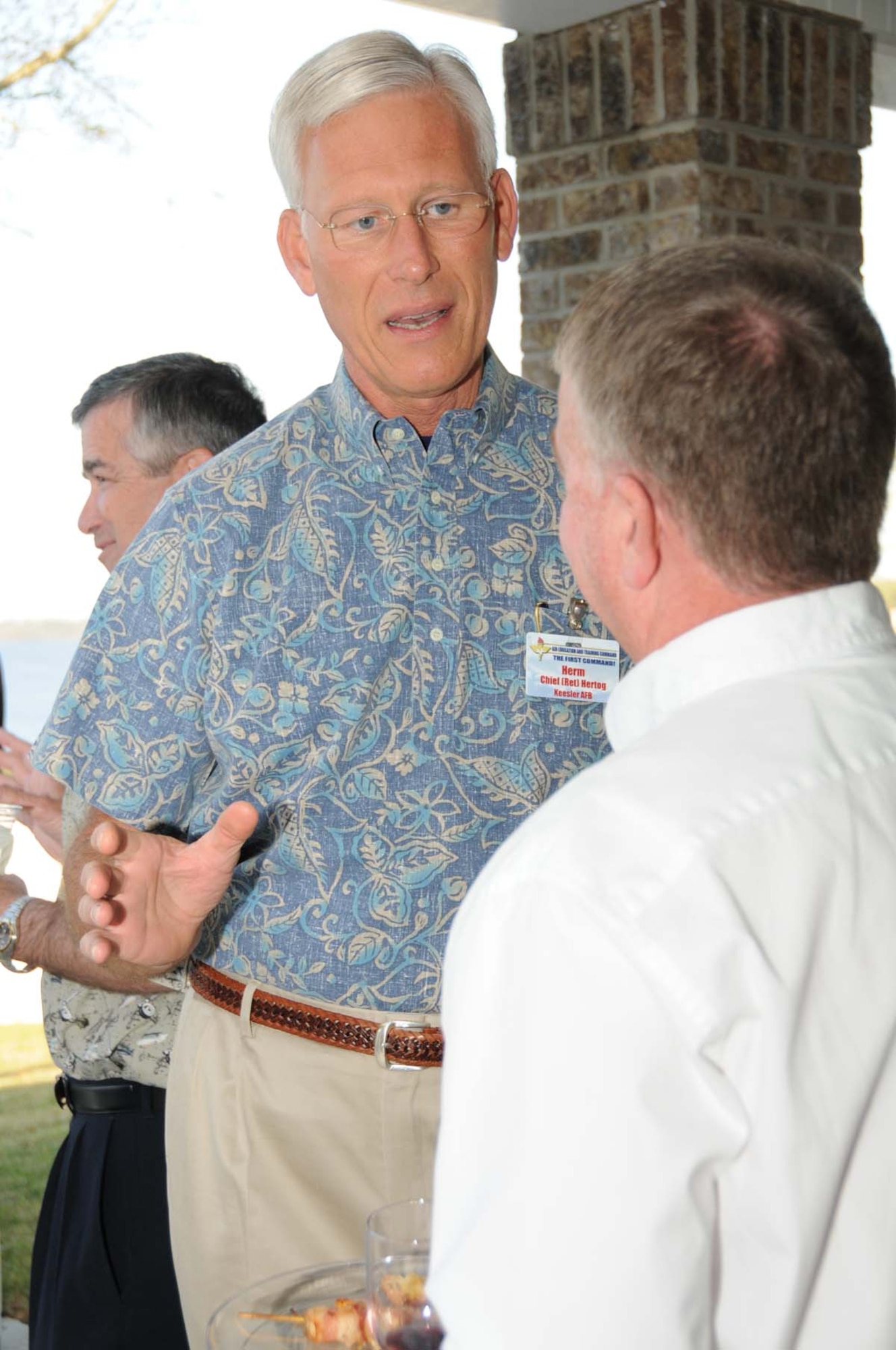 Retired chief master sergeant Herm Hertog, who's married to Maj. Gen. Mary Kay Hertog, 2nd Air Force commander, visits with Maj. Gen. Tom Travis, 59th Medical Wing commander, Lackland Air Force Base, Texas, during a social at the Hertog home March 30 during Air Education and Training Command's spring conference hosted by Keesler March 29 through April 1.  (U.S. Air Force photo by Kemberly Groue)