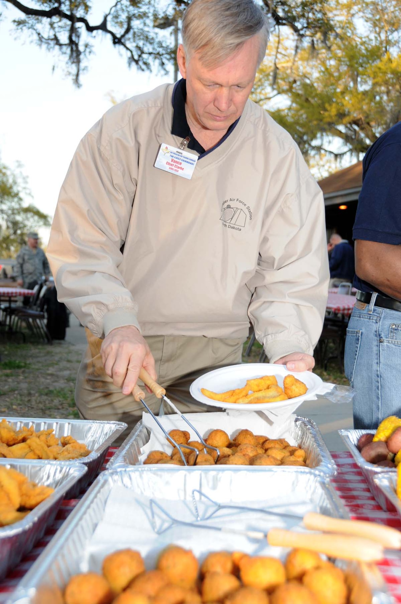 Chief Master Sgt. Vance Clark, Air Force Recruiting Service command chief, fills his plate during a fish fry March 31 at marina park hosted by the Biloxi Bay Chamber of Commerce.  Keesler hosted Air Education and Training Command's spring conference for 118 commanders, senior leaders and support staff March 29 through April 1.  (U.S. Air Force photo by Kemberly Groue)
