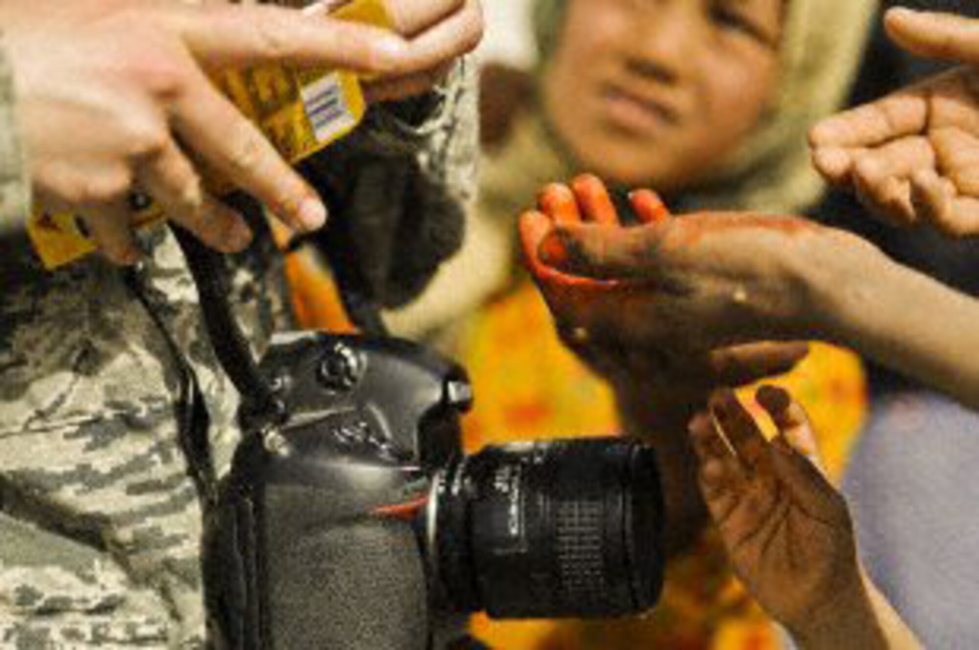 U.S. Air Force Staff Sgt. Christine Jones, a photographer with 4th Combat Camera Squadron, gives candy to Afghan children waiting to receive medical treatment at Lindenau Clinic in Main Operating Base Price, Helmand province, Afghanistan, March 16, 2010.  (U.S. Air Force photo/Technical Sgt. Efren Lopez) 
