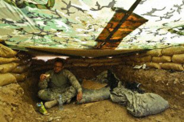 U.S. Air Force Technical Sgt. Rodolfo Castro, 4th Combat Camera Squadron, March Air Reserve Base, Calif., eats a snack in a fox hole during Operation Moshtarak, Helmand province, Afghanistan, Feb. 28, 2010.  Sergeant Castro and his teammate, Technical Sgt. Efren Lopez, also lived in one of these fox holes during the operation.  (U.S. Air Force photo/Technical Sgt. Efren Lopez) 
