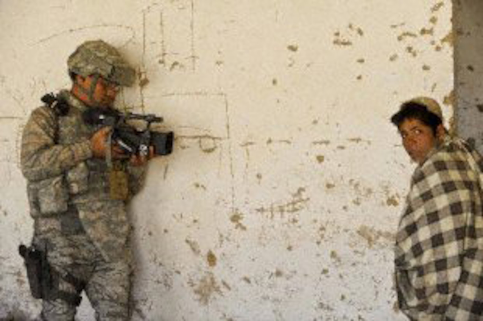 U.S. Air Force Technical Sgt. Rodolfo Castro, a videographer with 4th Combat Camera Squadron, March Air Reserve Base, Calif., documents a Medical Capabilities operation in Zakuzi Village, Zabul province, Afghanistan, Nov. 18, 2009.  MEDCAPs provide medical treatment to local Afghans as part of Operation Enduring Freedom.  (U.S. Air Force photo/Technical Sgt. Efren Lopez) 
