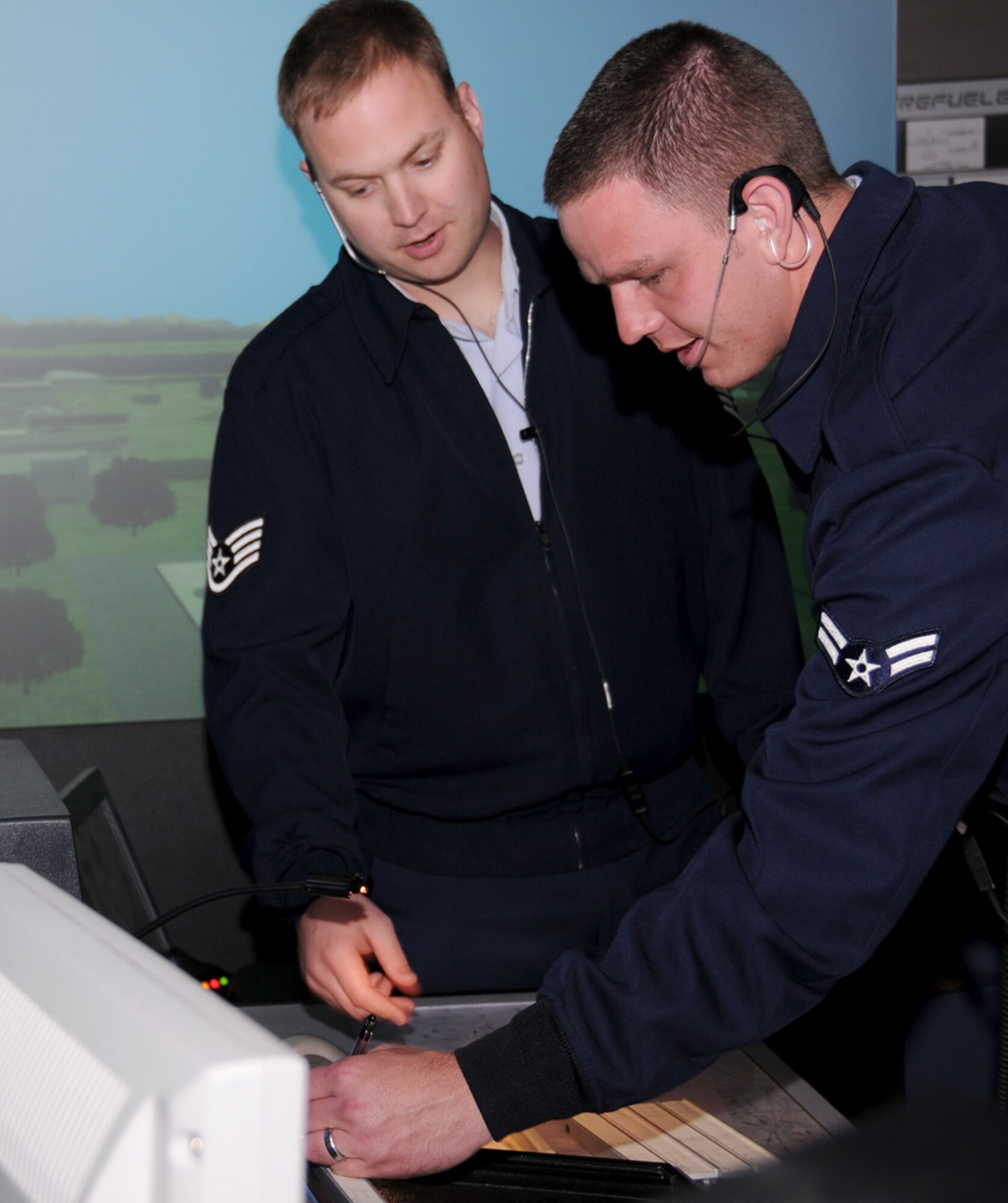 Sergeant Cope, left, works with Airman Menssen on the air traffic control simulator in Cody Hall.  (U.S. Air Force photo by Kemberly Groue)