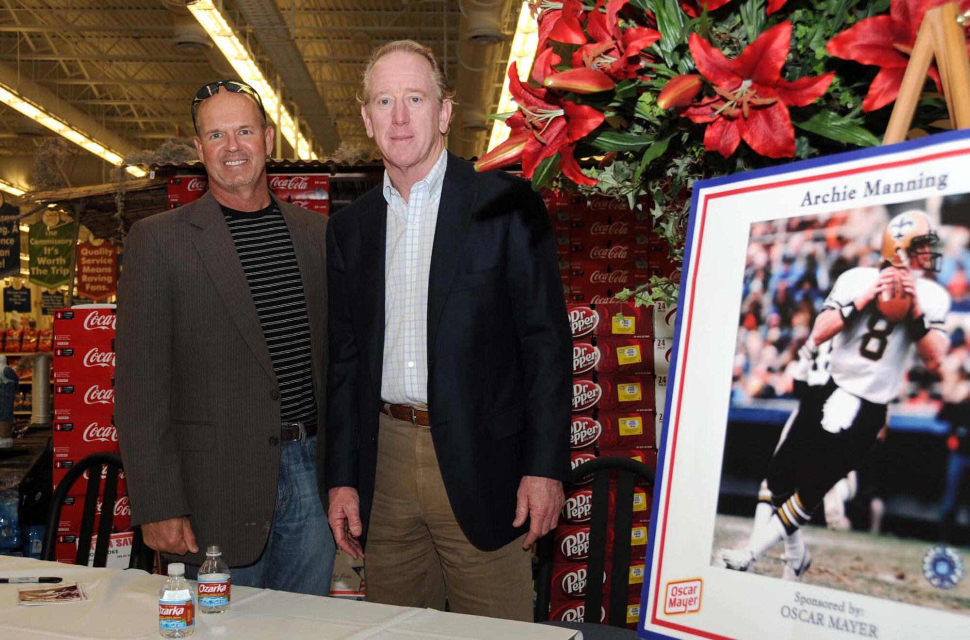 Florida artist Marlin Miller, who created a wood carving of an eagle for the new base exchange, poses with former New Orleans Saints quarterback Archie Manning after the ribbon-cutting for Keesler's new shopping complex.  In addition to the new exchange, the $60 million structure includes a modern commissary, pharmacy, food court, optical shop, GNC, a variety of concessionaires and beauty, nail and barber shops.  (U.S. Air Force photo by Kemberly Groue)