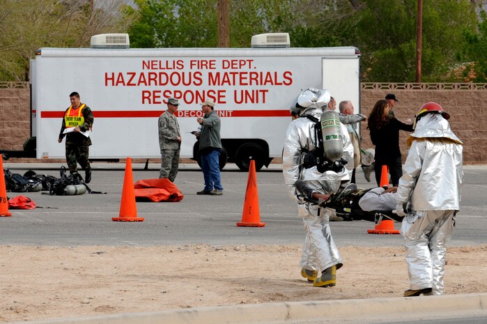 NELLIS AIR FORCE BASE, Nev. - 99th Civil Engineering Squadron fire fighters carries a victim back to the decontamination center during an All Hazard Response Exercise, March 25. The exercise tested first responders throughout the 99th Air Base Wing. (U.S. Air Force Photo by Airman 1st Class Brett Clashman/RELEASED)