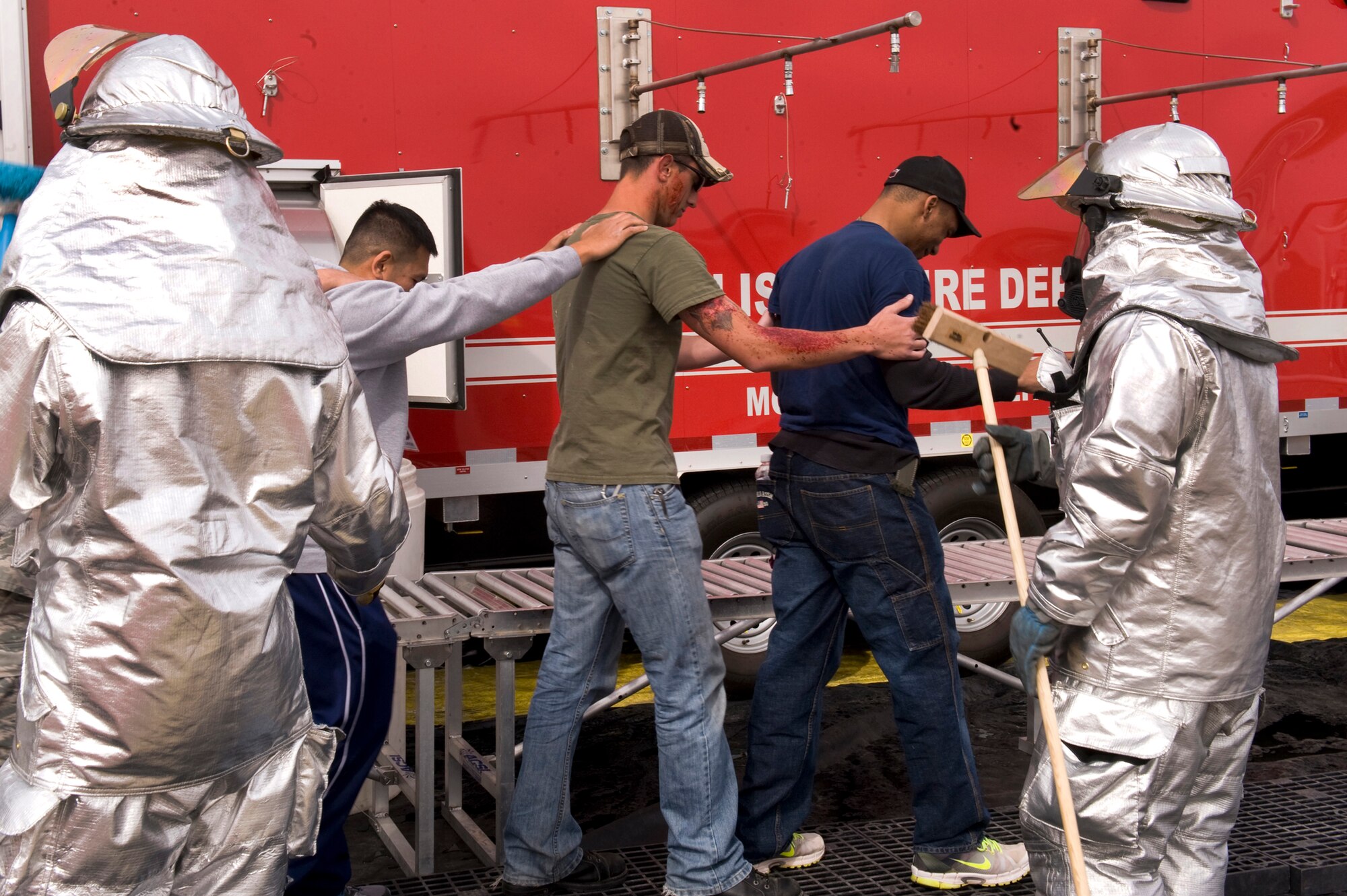 NELLIS AIR FORCE BASE, Nev. --  Airman participating as victims, in an All Hazard Response Exercise are guided through the decontamination line by 99th Civil Engineering Squadron fire fighters, March 25. The All Hazard Response Exercise tests first responders throughout the 99th Air Base Wing. 
(U.S. Air Force photo by Airman 1st Class Jamie Nicley/RELEASED)