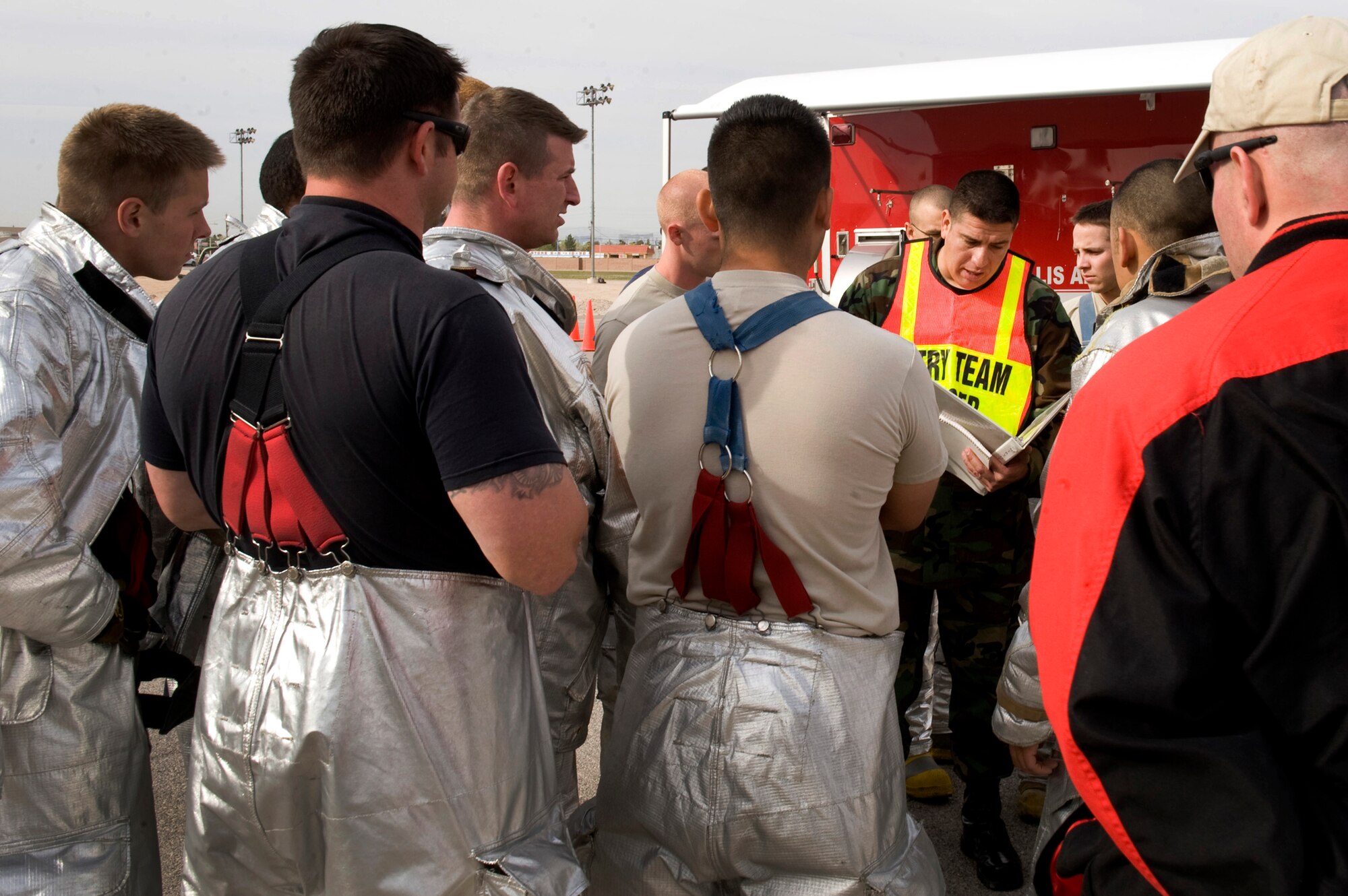 NELLIS AIR FORCE BASE, Nev. -- 99th Civil Engineer Squadron fire fighters receive a briefing before beginning an All Hazard Response Exercise, March 25. The All Hazard Response Exercise tests first responders throughout the 99th Air Base Wing. 
(U.S. Air Force photo by Airman 1st Class Jamie Nicley/ RELEASED)