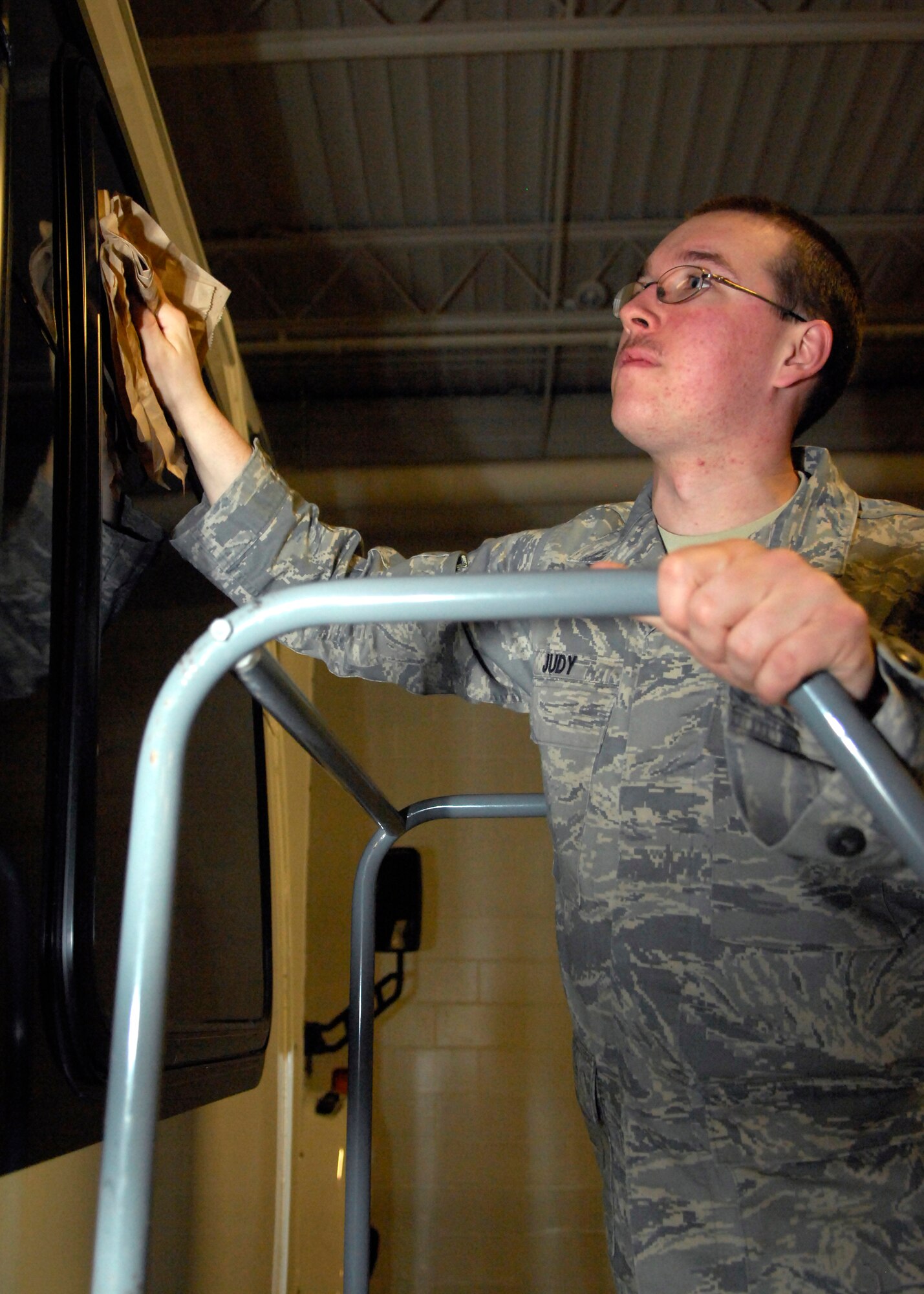 MINOT AIR FORCE BASE, N.D. -- Airman 1st Class Zachary Smith, 5th Logistics Readiness Squadron vehicle operations vehicle operator, cleans the windows of the shuttle that will be used for a distinguished visitor. Vehicle operations is also responsible for providing transportation for Airmen to all-calls, such as the one Maj. Gen. Floyd Carpenter, 8th Air Force commander, spoke at April 7. (U.S. Air Force photo by Airman 1st Class Ashley N. Avecilla)