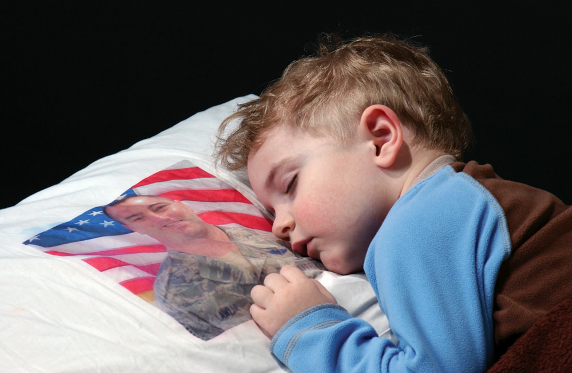 KEEPING DAD NEARBY -- This photograph of 3-year-old Blain Lawlor won the Portrait/Personality Photograph category in the 2009 Air Force Media Contest. The Airman and Family Readiness Center at Westover Air Reserve Base, Mass., created the pillowcase for Blain, so he could keep his dad, Master Sgt. Dan Lawlor, close during a deployment to Iraq. (U.S. Air Force photo/Staff Sgt. Hueming Mui)
