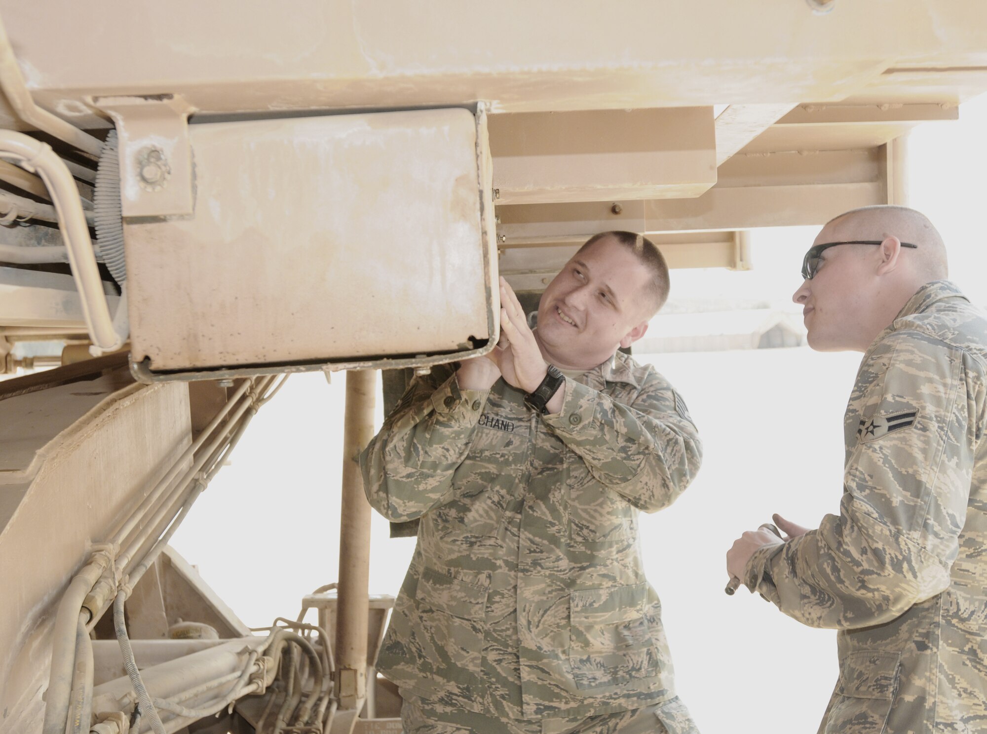 Tech. Sgt. Greg Marchand (left) and Airman 1st Class Chris Kuczynski, 506th Expeditionary Logistics Readiness Squadron vehicle maintainers, perform maintenance on a 25,000-pound cargo loader April 2, 2010, at Forward Operating Base Diamondback in Mosul, Iraq. These Airmen maintain three aircraft cargo loaders as well as two pick-up trucks on the Army-controlled airfield to support its movement control team mission. Sergeant Marchand is deployed from Bolling Air Force Base, D.C. and Airman Kuczynski is deployed from Hill AFB, Utah.  (U.S. Air Force photo/Staff Sgt. Tabitha Kuykendall)