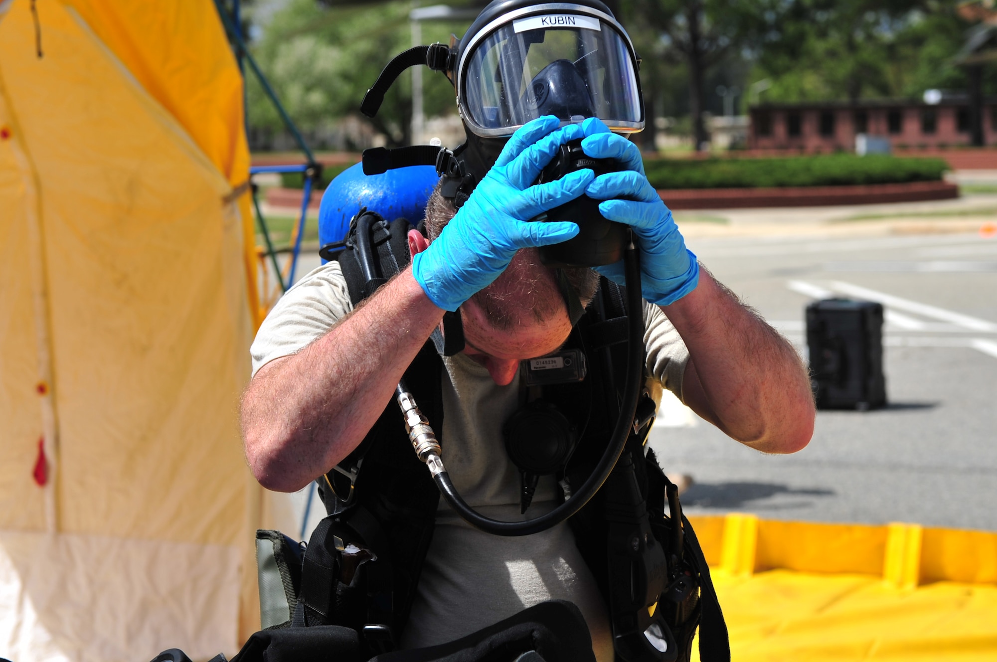 SEYMOUR JOHNSON AIR FORCE BASE, N.C. -- Army Staff Sgt. Michael Kubin removes his self-contained breathing apparatus after going through the decontamination line during a chemical, biological, radiological and nuclear hazard exercise here, March 30, 2010. Personnel entering a hot zone wear an SCBA to provide breathable air in an immediate-danger-to-life-and-health situation. Sergeant Kubin, a decontamination line NCO with the 42nd Civil Support Team North Carolina National Guard, is from Crosby, Texas. (U.S. Air Force photo/Senior Airman Rae Perry)