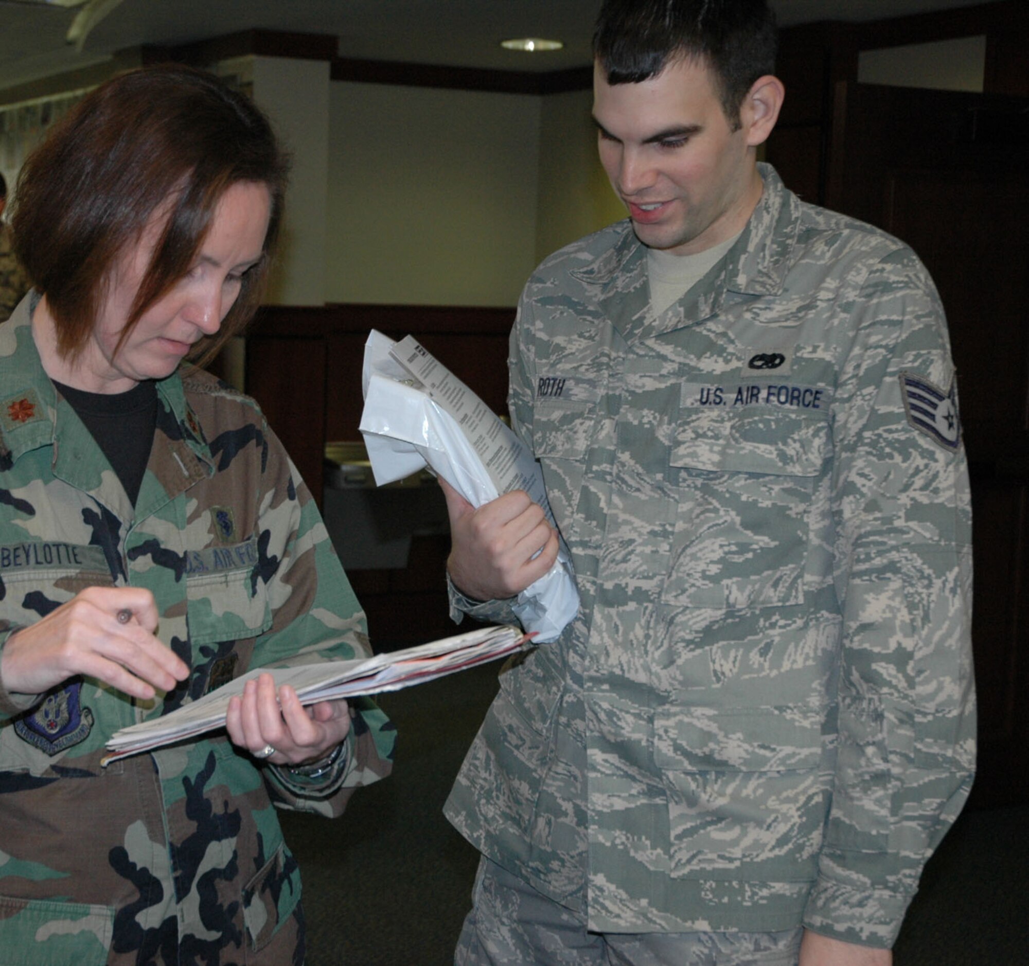 Major Ssan Beylotte and Staff Sergeant Austin Roth, 315th Airlift Wing, Charleston Air Force Base S.C., check over his medical records while inprocessing Tuesday in the base theater. Sergeant Roth and more than 250 other reservists have been activated to support the surge of U.S. forces in Afghanistan