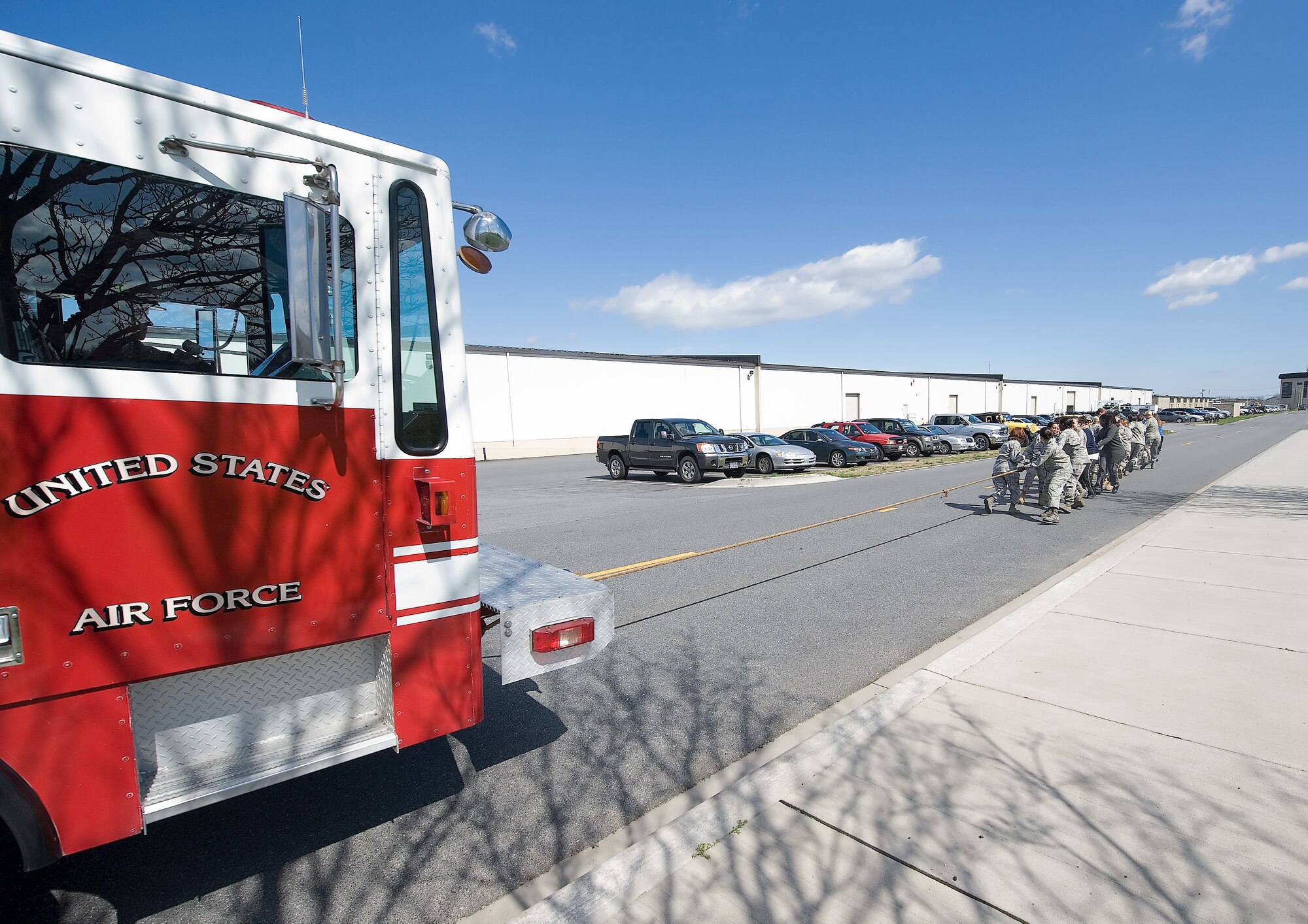 Military members pull a nearly 3,000 pound fire truck 100 yards in a little over a minute March 31.  The event was held to support Women?s History Month theme ?Strength in Numbers.?  (U.S. Air Force Photo / Brianne Zimny)