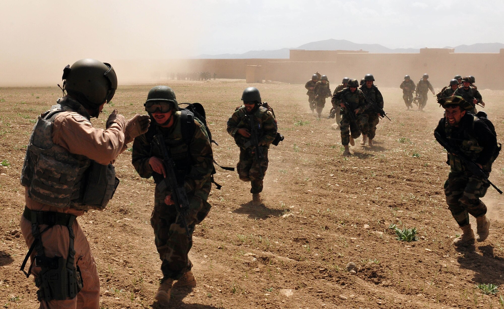 U.S. Air Force Tech. Sgt. Cain Garrett from the 438th Air Expeditionary Advisory Group, Combined Air Power Transition Force, directs Afghan commandos from the 6th Commando Kandak toward an Afghan National Army Air Corps Mi-17 helicopter April 1, 2010, in the Pul-e Alam district of the Logar region. The commandos conducted an air-assault mission to disrupt insurgent activity and bring stability to the population in the region. (US Navy photo by Mass Communication Specialist 2nd Class David Quillen/ RELEASED)