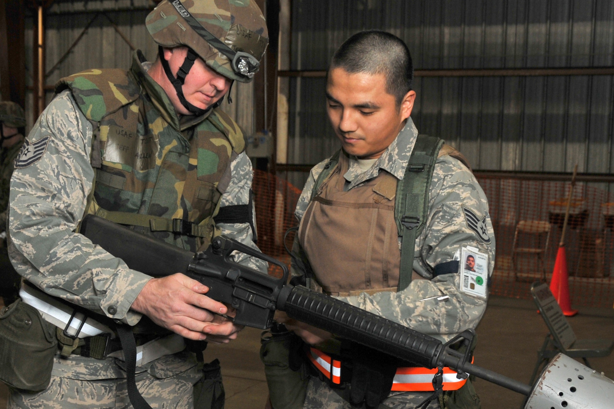 VOLK FIELD ANGB, Wisc., --  Tech. Sgt. Jeffrey Allen clears his weapon with assistance from Staff Sgt. Mark Garcia at the armory. Reservists from Grissom Air Reserve Base, Ind., and Guardsmen from Martinsburg, W.Va., teamed together for an operational readiness  inspection. (U.S. Air Force photo/Master Sergeant Emily Beightol-Deyerle)