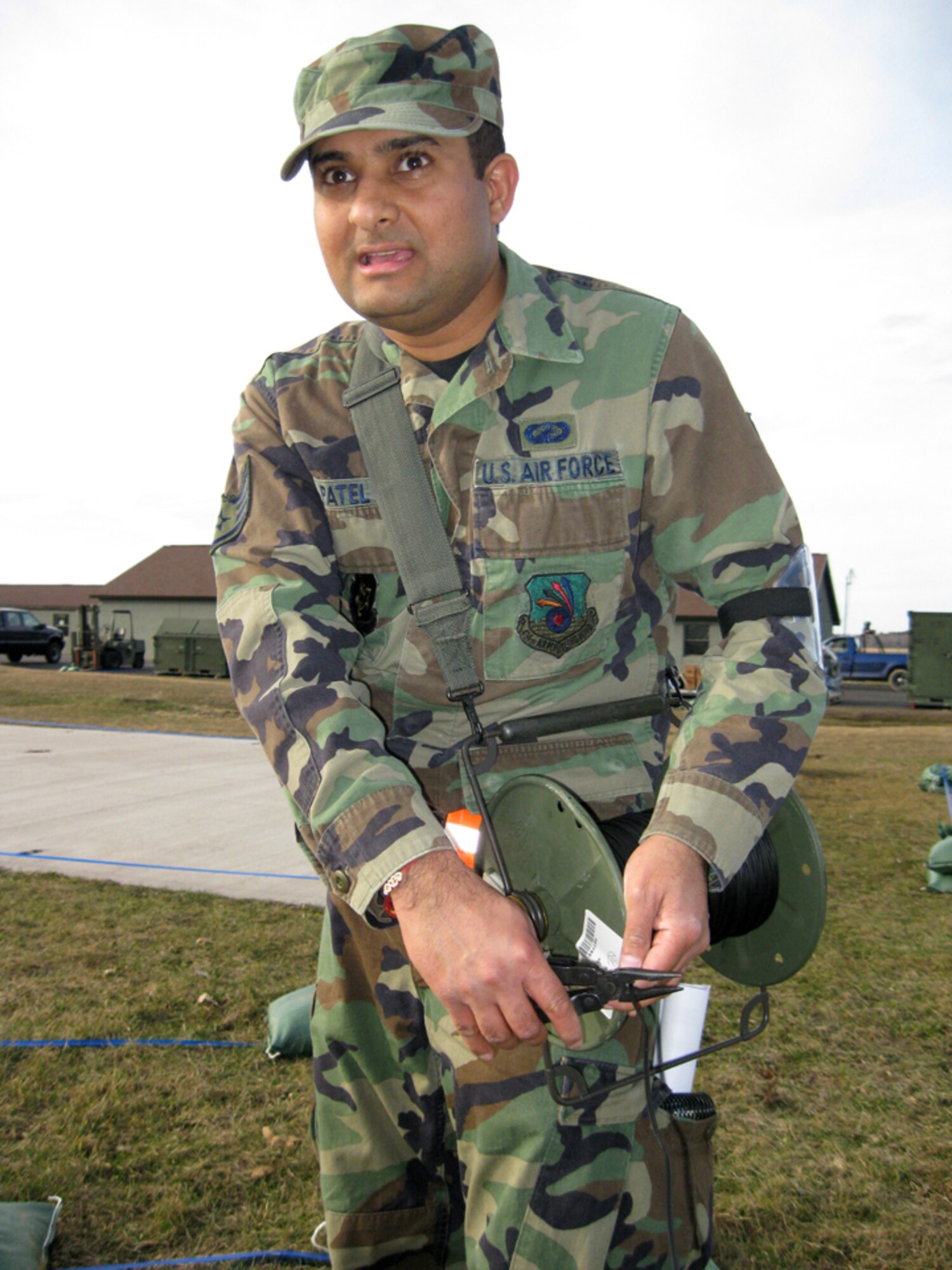 GRISSOM AIR RESERVE BASE, Ind., -- Staff Sgt. Nishant Patel, a computer support specialist, cuts a communications line while at Volk Field, Wisc.  Reservists from Grissom and Guardsmen from Martinsburg, W.V., teamed together for an operational readiness inspection.  (U.S. Air Force photo/Tech. Sgt. Mark R. W. Orders-Woempner)
