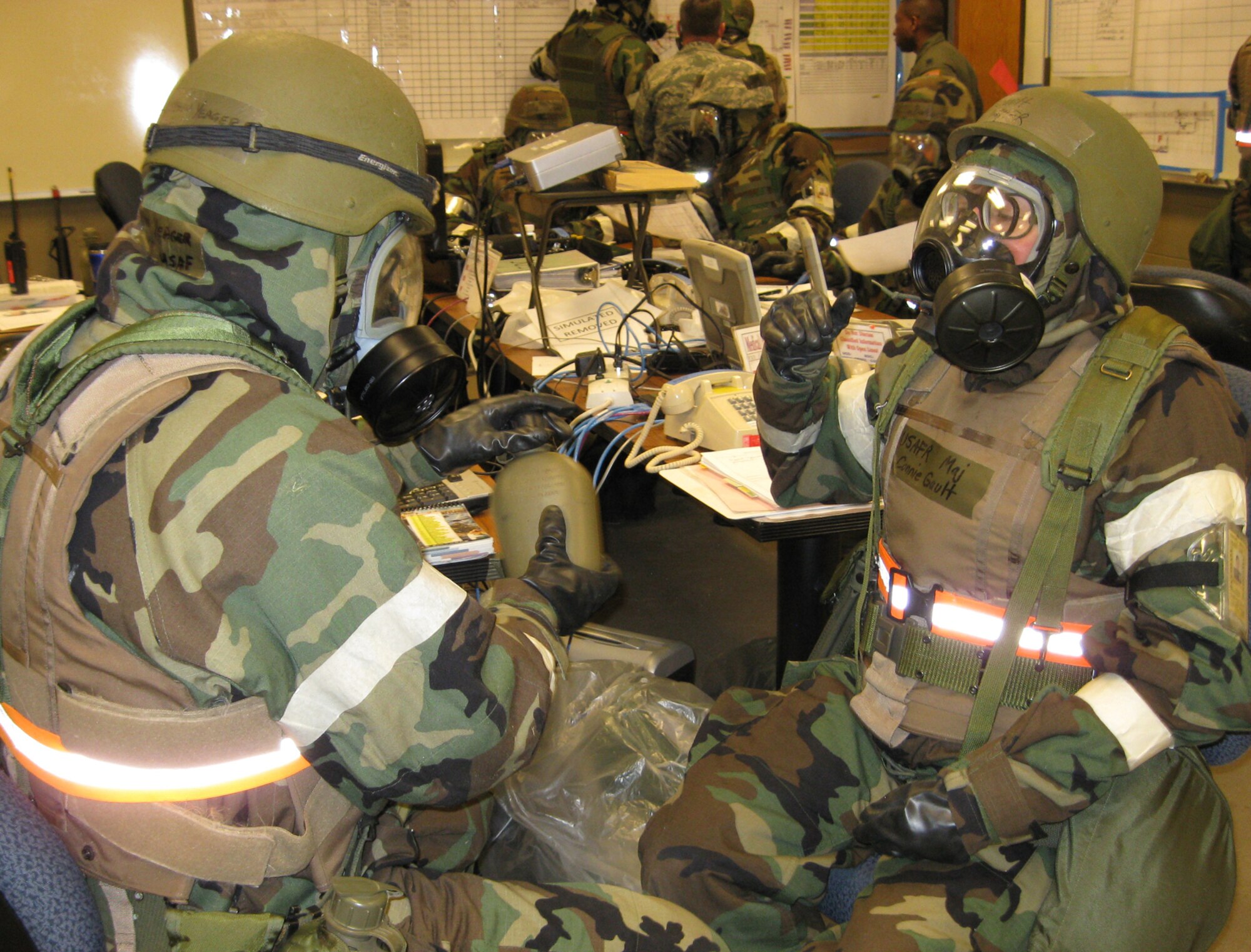 VOLK FIELD ANGB, Wisc., --  Master Sgt. Kevin Yeager, a personnel assistance manager with the 434th Mission Supports Squadron, assists Major Connie Gault, a nurse with the 434th Aerospace Medicine Squadron, with her canteen during a recent operational readiness inspection.  Drinking out of a canteen while dressed in full protective gear is one of the graded requirements during the inspection.   (Air Force photo/ Staff Sgt. Ben Mota)                  