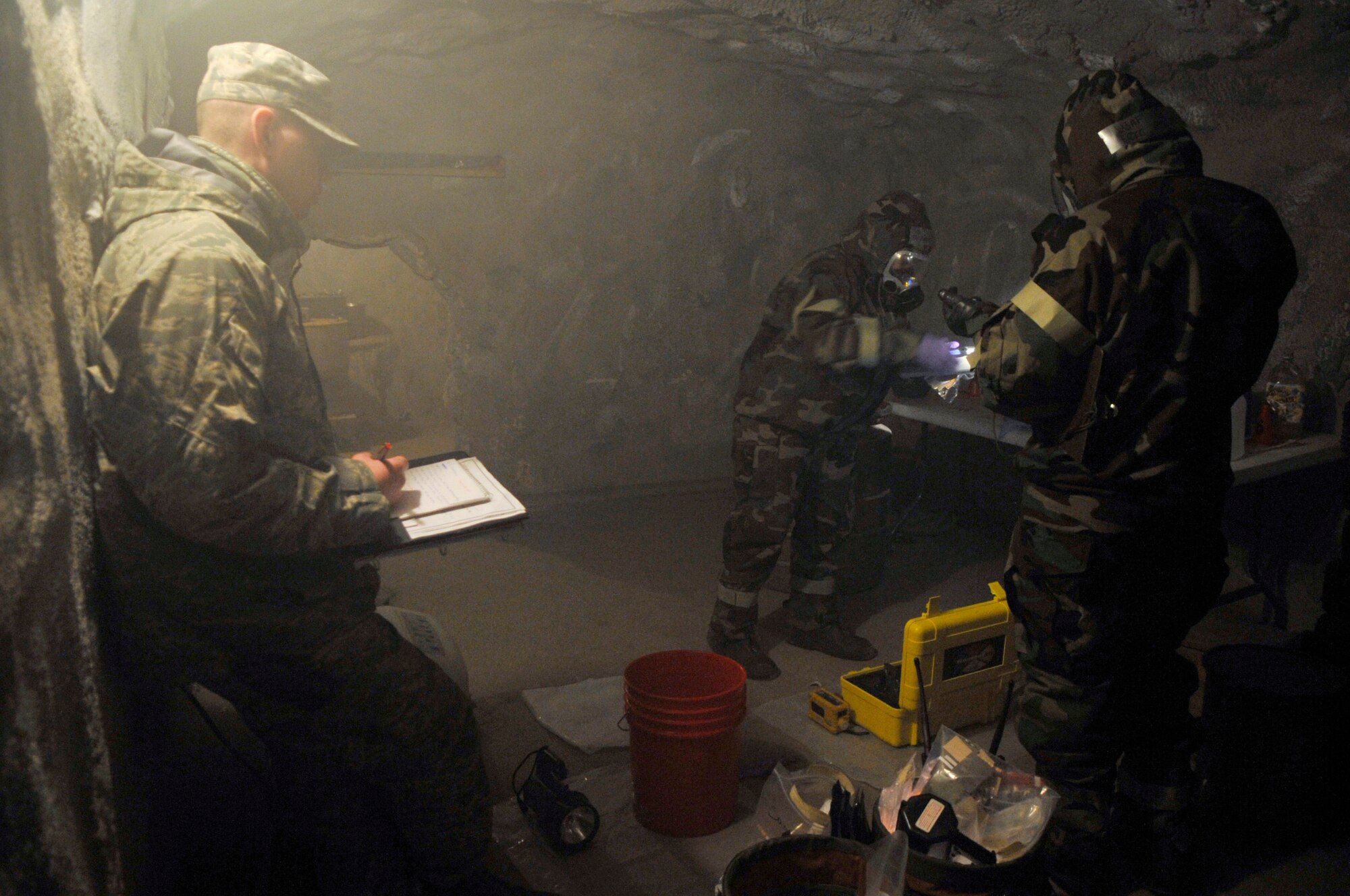 Staff Sgt. Parker Stade observes as Airman 1st Class Eric Reist and Staff Sgt. Charlotte Robinson sample an unknown liquid from a bottle at a simulated deployment location as part of an Air Force District of Washington CBRNE Response Force team. The team trained at the Center for National Response in Gallagher, W.Va., Mar. 25, 2010. The Response Force is made up of personnel from the 316th Wing, 79th Medical Wing and 11th Wing. It is a force that combines Bio-environmental Engineers, Civil Engineering Readiness and Emergency Management and Fire Emergency services to respond to emergency situations on AFDW installations and possibly in the National Capital Region. (U.S. Air Force photo by Staff Sgt. Renae L. Saylock)(released) 