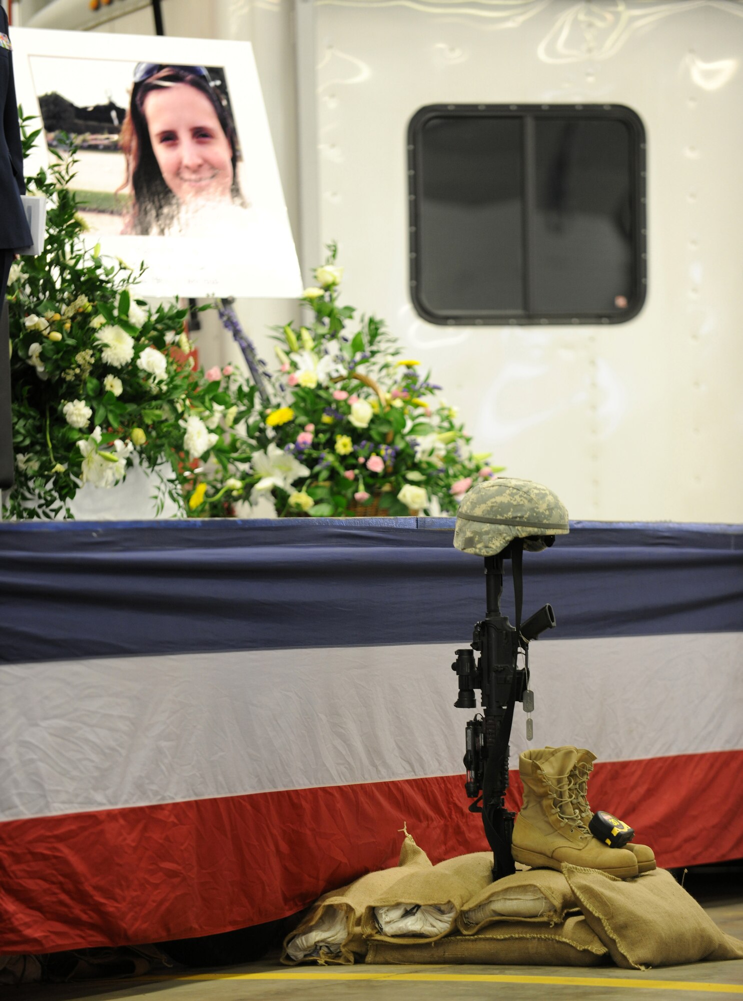 RAF MILDENHALL, England – A traditional military tribute memorial lays at the front of the stage during a memorial ceremony held April 7 for Capt. Jenna Wilcox, 100th Civil Engineer Squadron, who was recently killed in a vehicle-related accident.  Hundreds of supporters attended the ceremony, including Captain Wilcox’s friends, family and coworkers.  (U.S. Air Force photo/Staff Sgt. Jerry Fleshman)