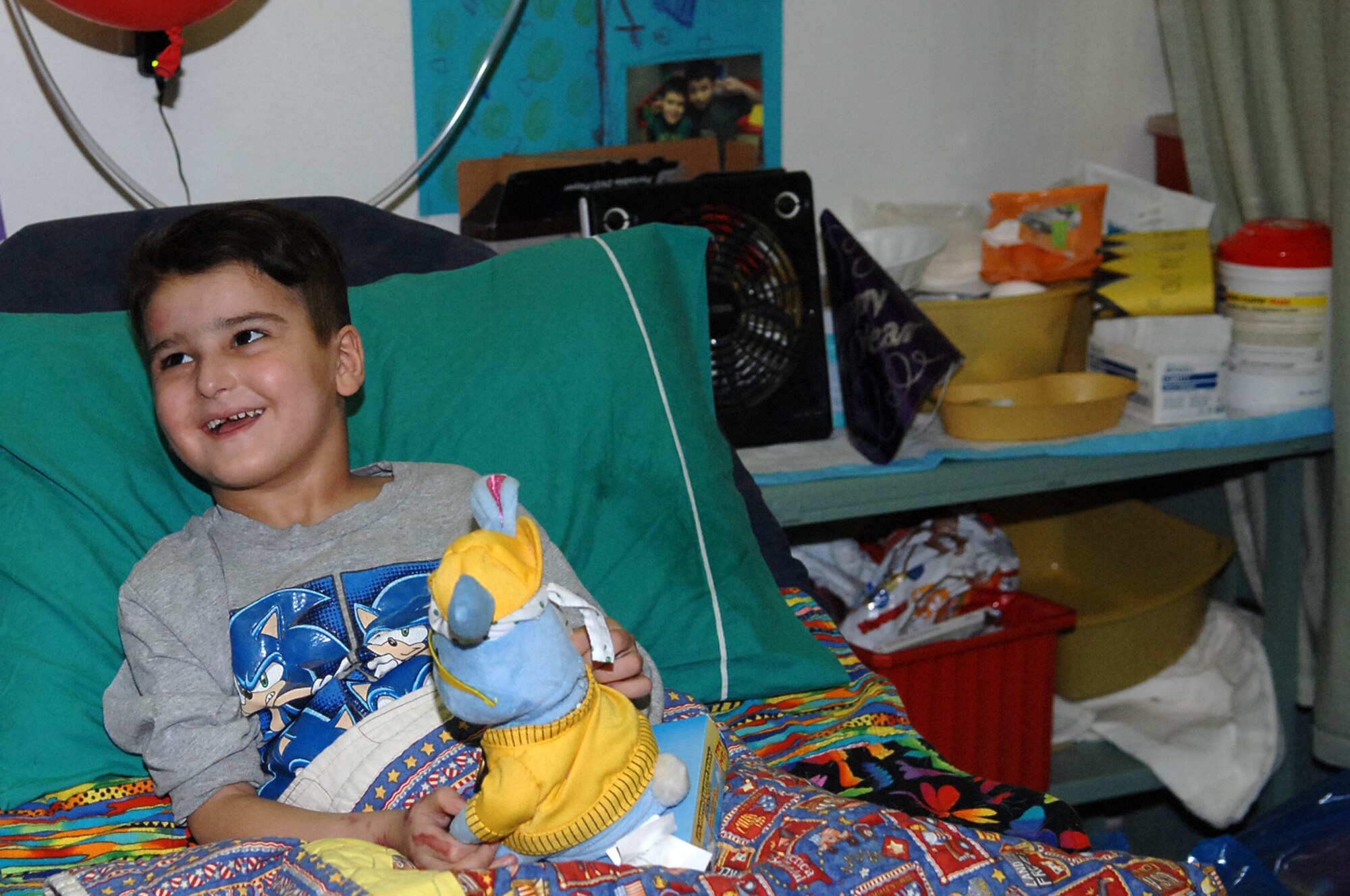 Six-year-old Sajad Hany Shaker Mahmud, a survivor of an improvised
explosive device attack, laughs as he plays with a birthday gift.Sajad celebrated his sixth birthday while recovering at the Air Force Theater Hospital. He received multiple presents and birthday wishes from the medical staff who have taken care of him during his 72-day stay at the hospital. (U.S. Air Force photo/Airman 1st Class Allison M. Boehm/Released)
