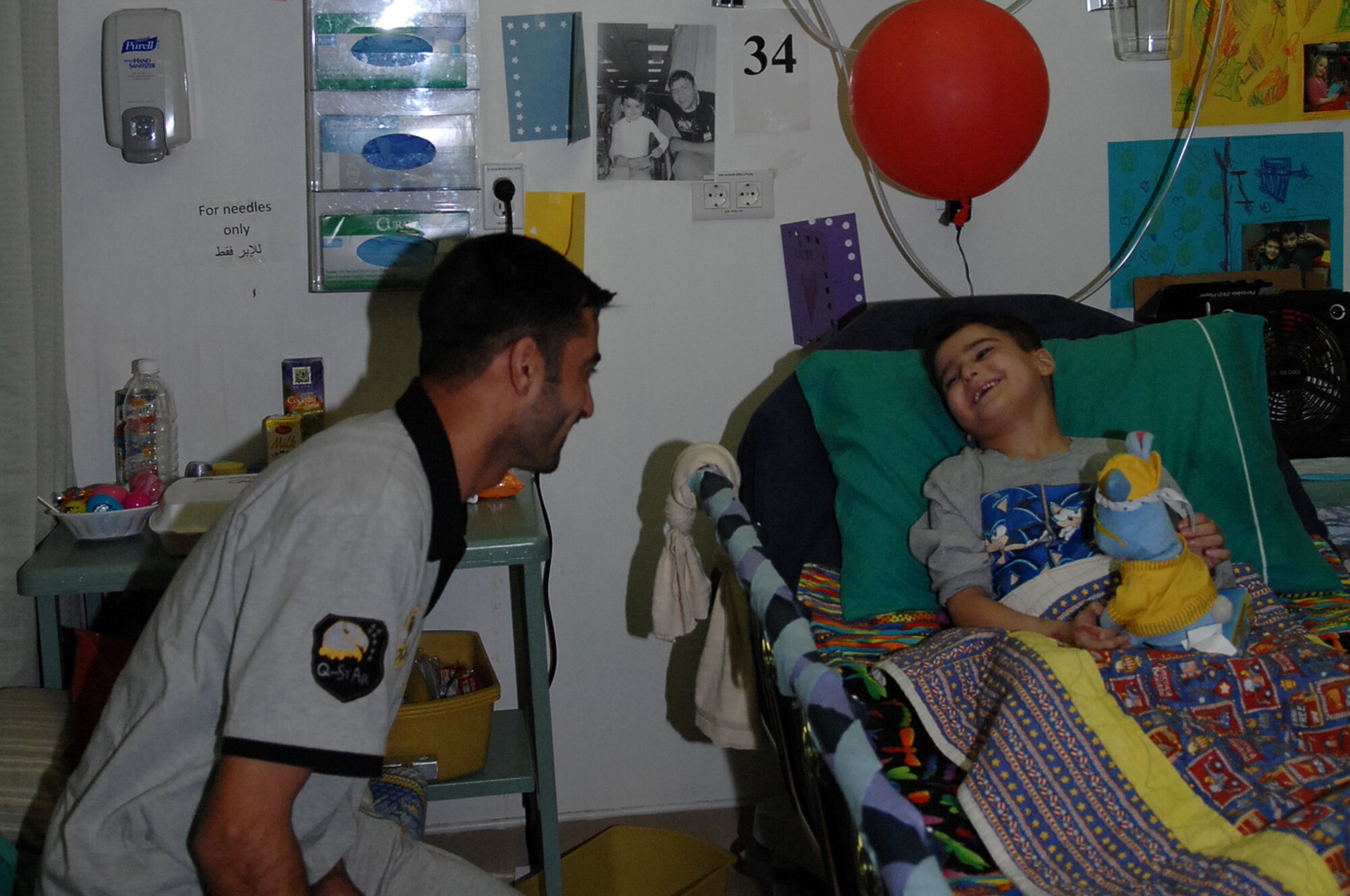 Six-year-old Sajad Hany Shaker Mahmud, a survivor of an improvised
explosive device attack, plays with a birthday gift with his father as they celebrate his sixth birthday while recovering at the Air Force Theater Hospital. Sajad received multiple presents and birthday wishes from the medical staff who have taken care of him during his 72-day stay at the hospital. (U.S. Air Force photo/Airman 1st Class Allison M. Boehm/Released)
