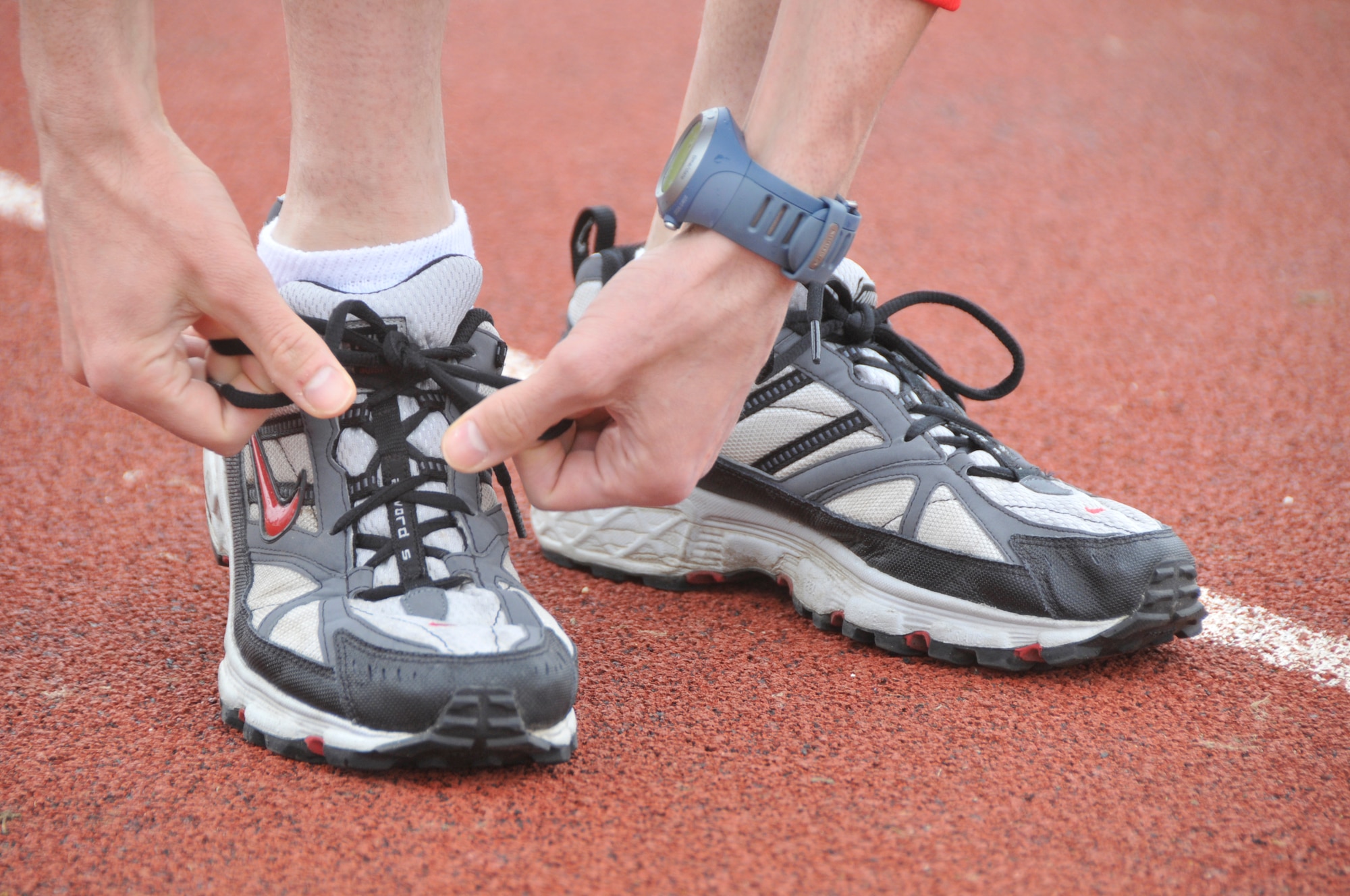 Staff Sgt. Robert Abato, 48th Communications Squadron postal specialist, tightens his shoelaces in preparation for his routine marathon training run on the track at RAF Lakenheath, England, March 13. (U.S. Air Force photo/2nd Lt. Ashley Skillman)