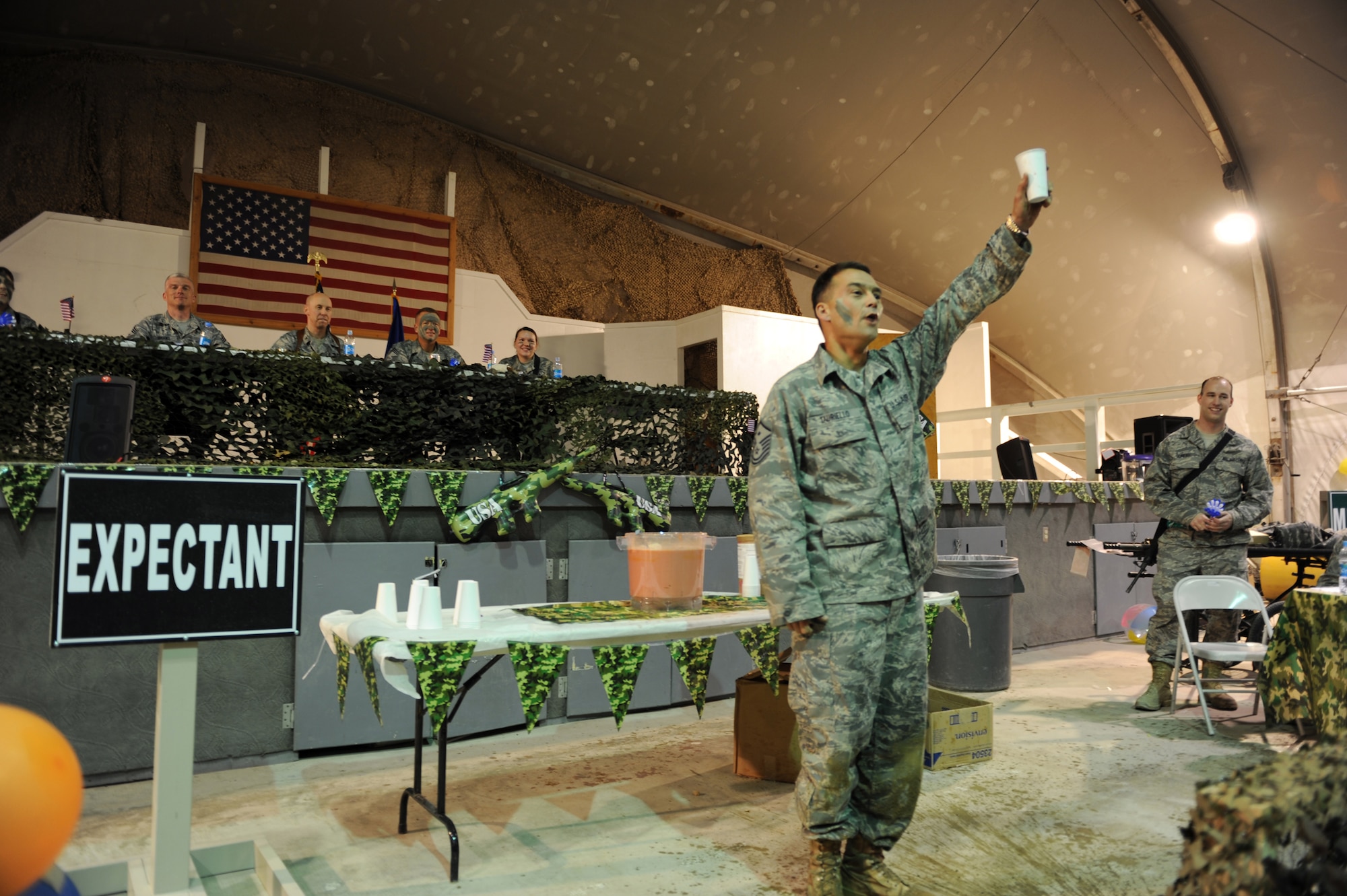 Master Sgt. Donovan Tauriello, 455th Expeditionary Medical Group/Task Force Medical East, first sergeant, toasts the mess after completing his run through the obstacle course during a combat dining in here, March 31, 2010. Sergeant Tauriello is deployed from MacDill Air Force Base, Fla. and is a native of Colombus, Ga. (U.S. Air Force photo by/ Staff Sgt Richard Williams)