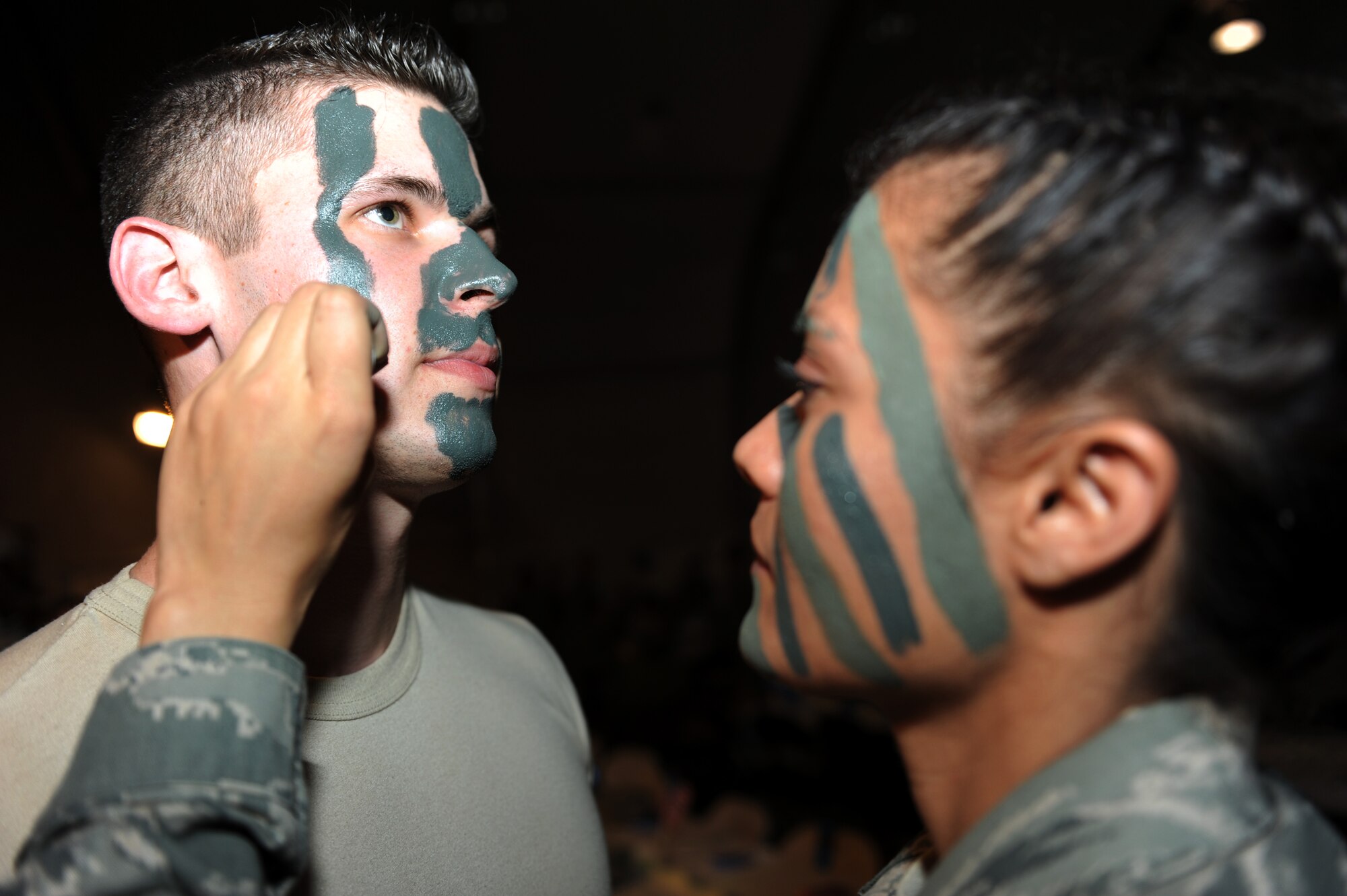 Major Timothy McDowell, 455th Expeditionary Medical Group/Task Force Medical East, chief of pharmacy operations receives his camaflouge paint from Senior Airman Danielle Acosta, 455th EMDG/TF MED-E, contingency aeromedical staging facility technician, in preparation for the combat dining in here, March 31, 2010. Major McDowell is deployed from Offutt Air Force Base, Neb. and is a native of Omaha, Neb. Airman Acosta is deployed from Travis AFB and is a native of Tracy, Calif. (U.S. Air Force photo by/Staff Sgt. Richard Williams)