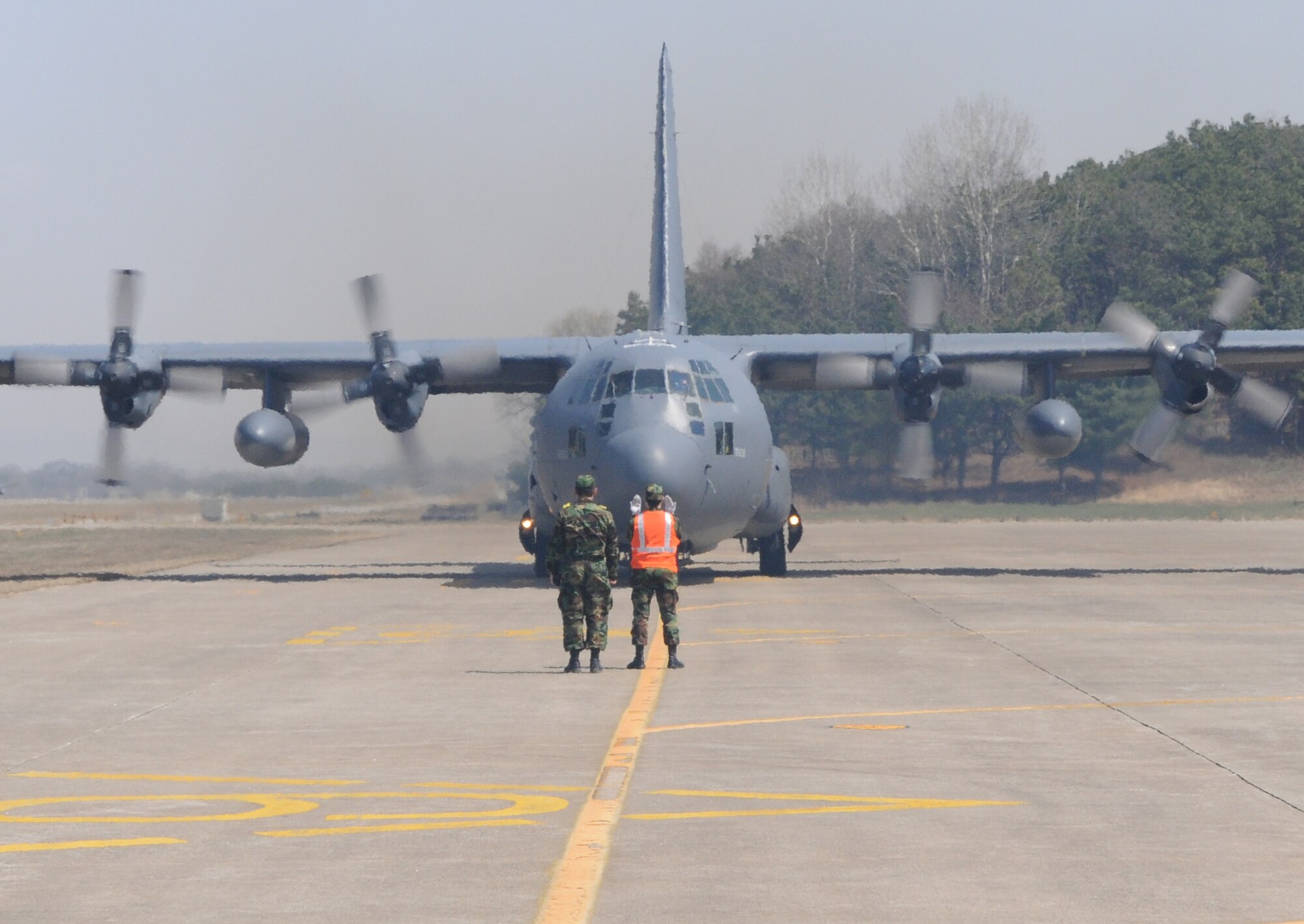 CHEONG JU AIR BASE, Republic of Korea -- A member of the Republic of Korea Air Force marshals a 17th Special Operations Squadron MC-130P Combat Shadow to its parking spot here April 2. More than 70 U.S. and ROK Army soldiers jumped from two MC-130P's as part of a friendship jump between the two armies. (U.S. Air Force photo by Tech. Sgt. Aaron Cram)