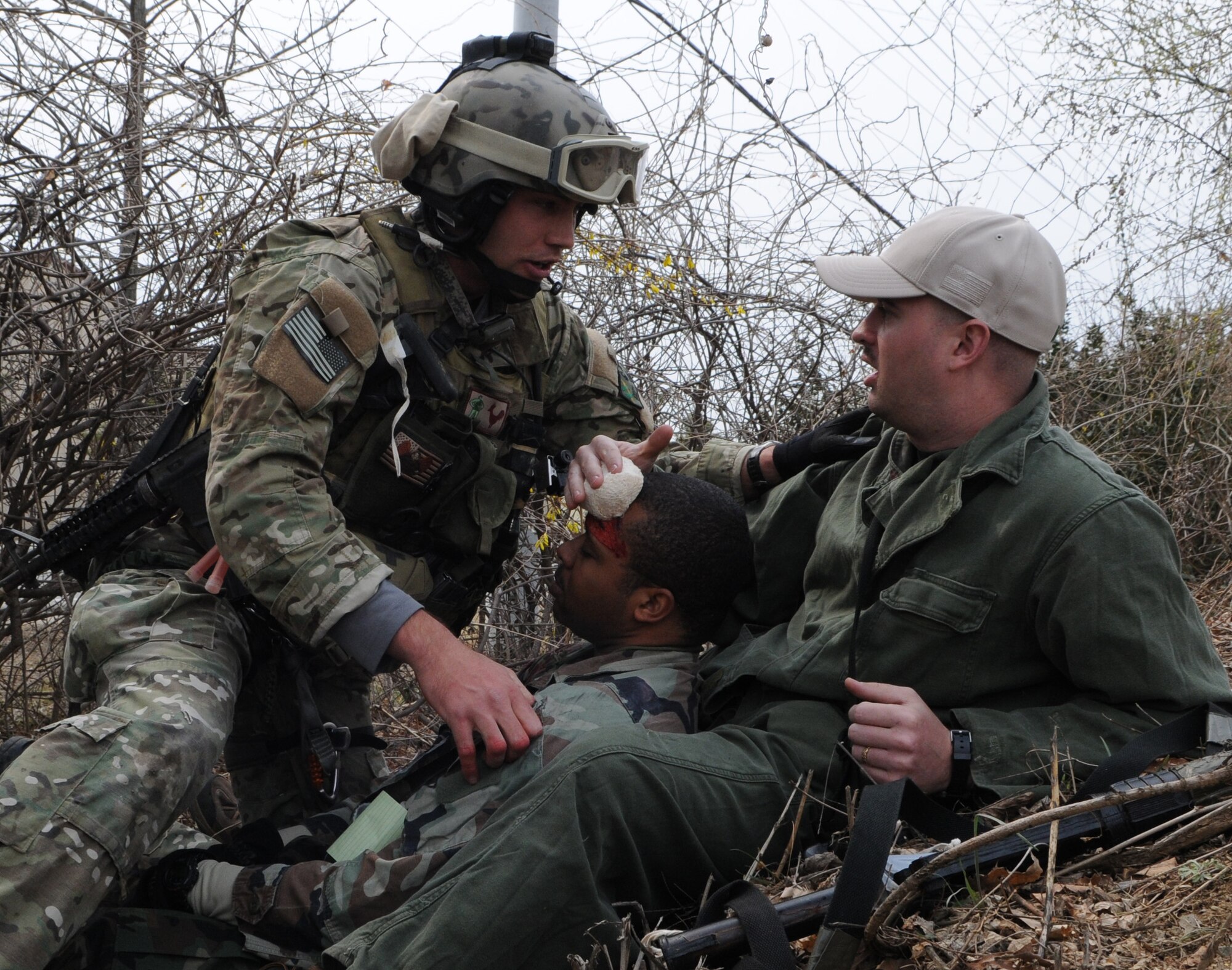 DAEGU AIR BASE, Republic of Korea -- Senior Airman Cody Cerny, a pararescueman from the 320th Special Tactics Squadron, tells Staff Sgt. Brain McDermitt to hold pressure on a simulated head wound on Staff Sgt. Raphael Thompson during a mass casualty exercise here March 27. The scenario is part of the 353rd Special Operations Group’s annual operational readiness exercise. (U.S. Air Force photo by Tech. Sgt. Aaron Cram)