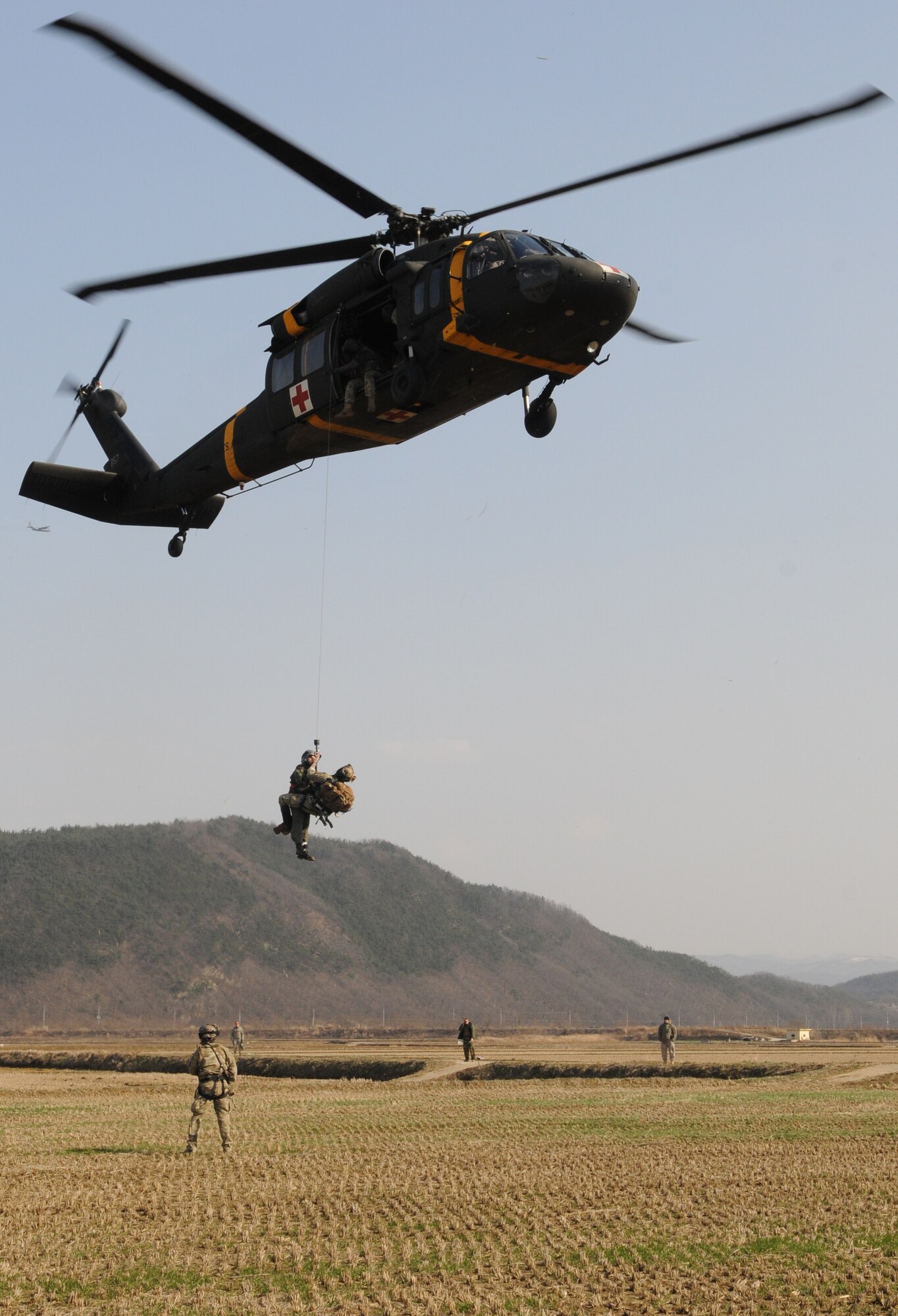NEAR AN’GANG, Republic of Korea -- A pararescueman from the 320th Special Tactics Squadron and a simulated wounded aircrew member are hoisted into a UH-60 Blackhawk from the 2nd Combat Aviation Brigade from U.S. Army Garrison Humphreys during a combat search and rescue exercise here March 26. The scenario is part of the 353rd Special Operations Group’s annual operational readiness exercise. (U.S. Air Force photo by Tech. Sgt. Aaron Cram)