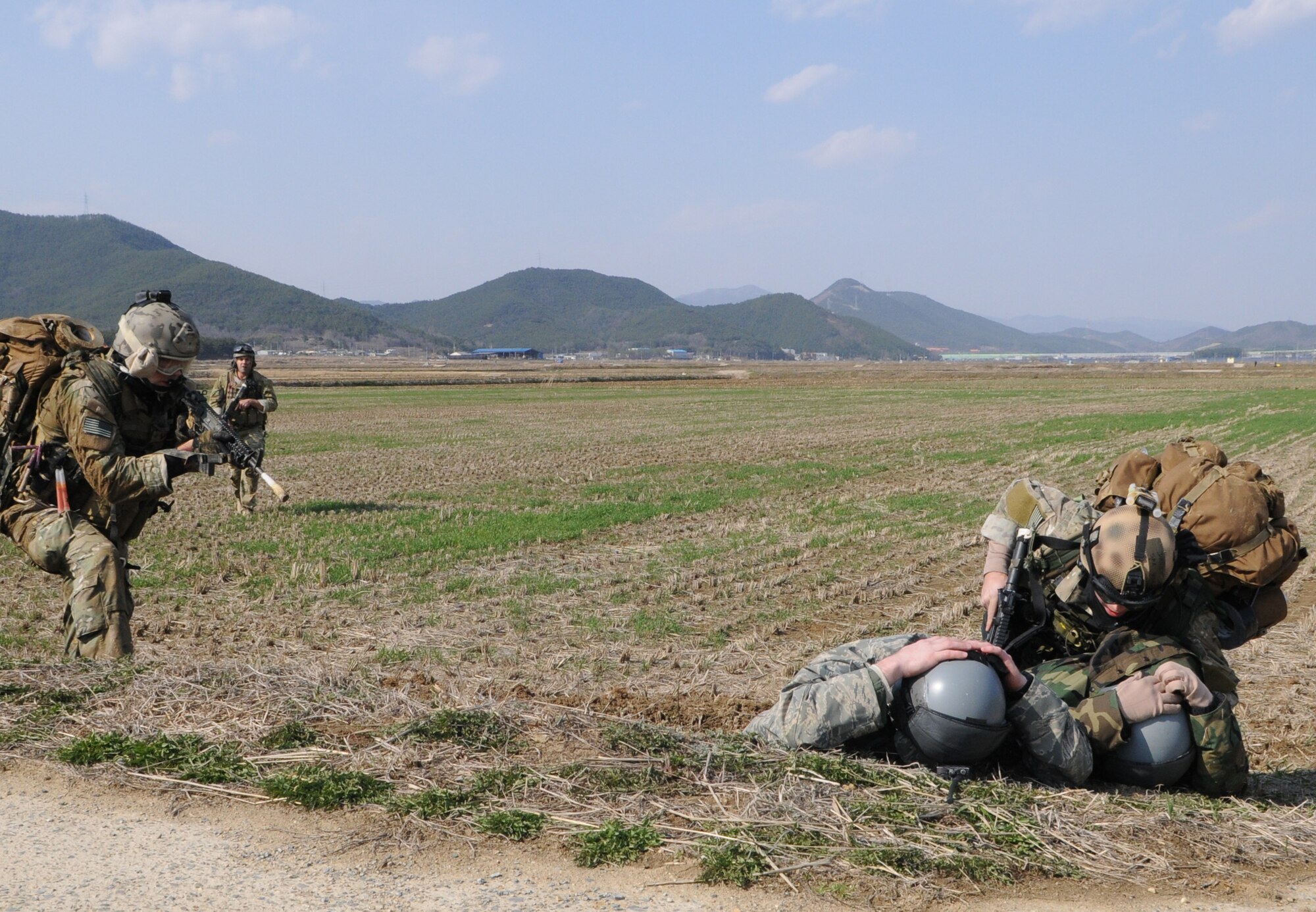 NEAR AN’GANG, Republic of Korea -- Senior Airman David Craig verifies the identity of two simulated aircrew members as Senior Airman Cody Cerny provides cover during a combat search and rescue exercise here March 26.The pararescuemen from the 320th Special Tactics Squadron had to locate and treat two simulated wounded aircrew members before calling for evacuation during the scenario.  The scenario is part of the 353rd Special Operations Group’s annual operational readiness exercise. (U.S. Air Force photo by Tech. Sgt. Aaron Cram)