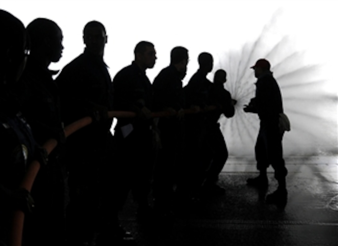 U.S. Navy sailors aboard the aircraft carrier USS George H.W. Bush (CVN 77) practice manning a fire hose during a Damage Control Olympics event in the hangar bay of the ship underway in the Atlantic Ocean conducting training on April 3, 2010.  