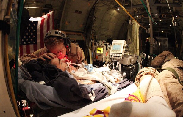 Then- U.S. Air Force Maj. Debora Lehker, a reserve critical care air transport team nurse, comforts a wounded Canadian army soldier aboard a C-130 Hercules during an emergency airlift from Kandahar Airfield, Afghanistan, Feb. 14, 2010. Aeromedical Evacuation team members are considered flight crew, meaning they must be familiar with the C-130 aircraft in addition to the medical specialty they practice. They need to know how to configure the aircraft to accommodate patient litters and know how the electricity works for the machines used to keep patients safe in flight. (Courtesy photo)