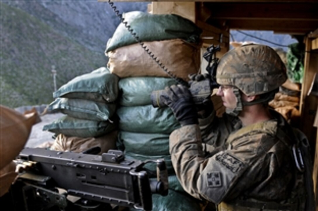 U.S. Army Spc Colin T. McTamaney checks a nearby ridge following an attack on Combat Outpost Bar Alai in Kunar province, Afghanistan, April 5, 2010. Multiple insurgents with automatic machine guns opened fire about seven hours after a sniper also shot at the base. No members of Afghan or international forces were injured. McTamaney is a a team leader assigned to Troop C, 3rd Squadron, 61st Cavalry Regiment.