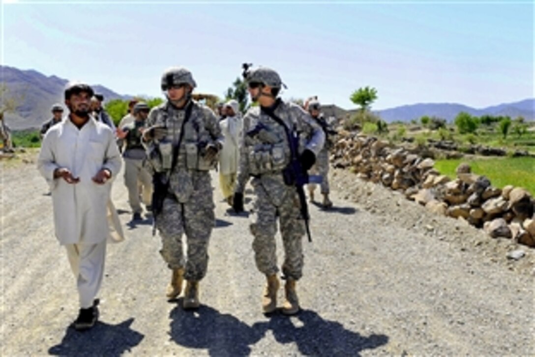 U.S. Navy Master Chief Petty Officer Glenn Niematalo, center, and Lt. j.g. Anthony Delgadillo talk to a construction site engineer about some of the villagers' concerns about road construction in Khost province, Afghanistan, April 5, 2010. Niematalo and Delgadillo are engineers assigned to the Khost Provincial Reconstruction Team.